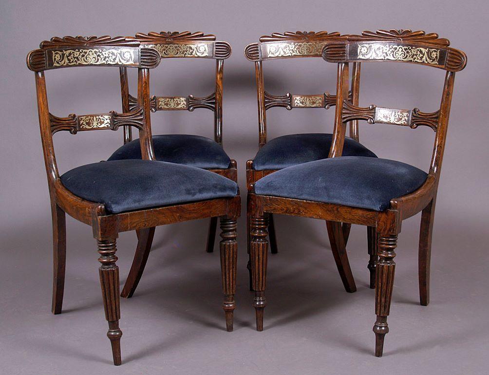 A set of four Regency-style chairs with a wooden backrest and an upholstered seat. The whole is supported by four legs, the front legs are turned, grooved, fluted, with a slender ending, and the rear saber legs are an extension of the structure. The