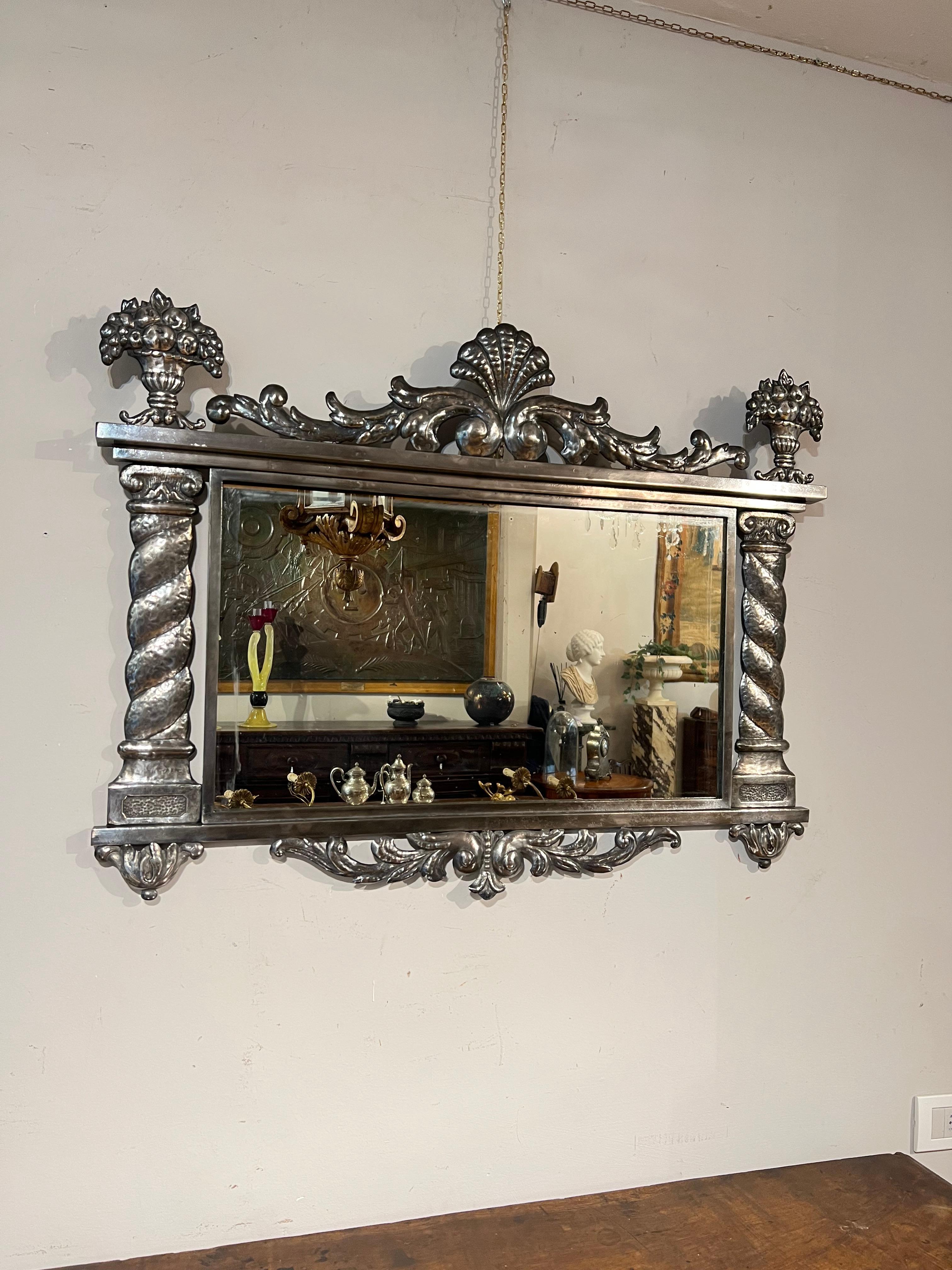 Beautiful mirror in silvered metal, Italian manufacture from the beginning of the 19th century.
Cymace centered by a shell motif, sides made as two twisted columns ending in a basket of flowers.

MEASUREMENTS: 73x95 cm