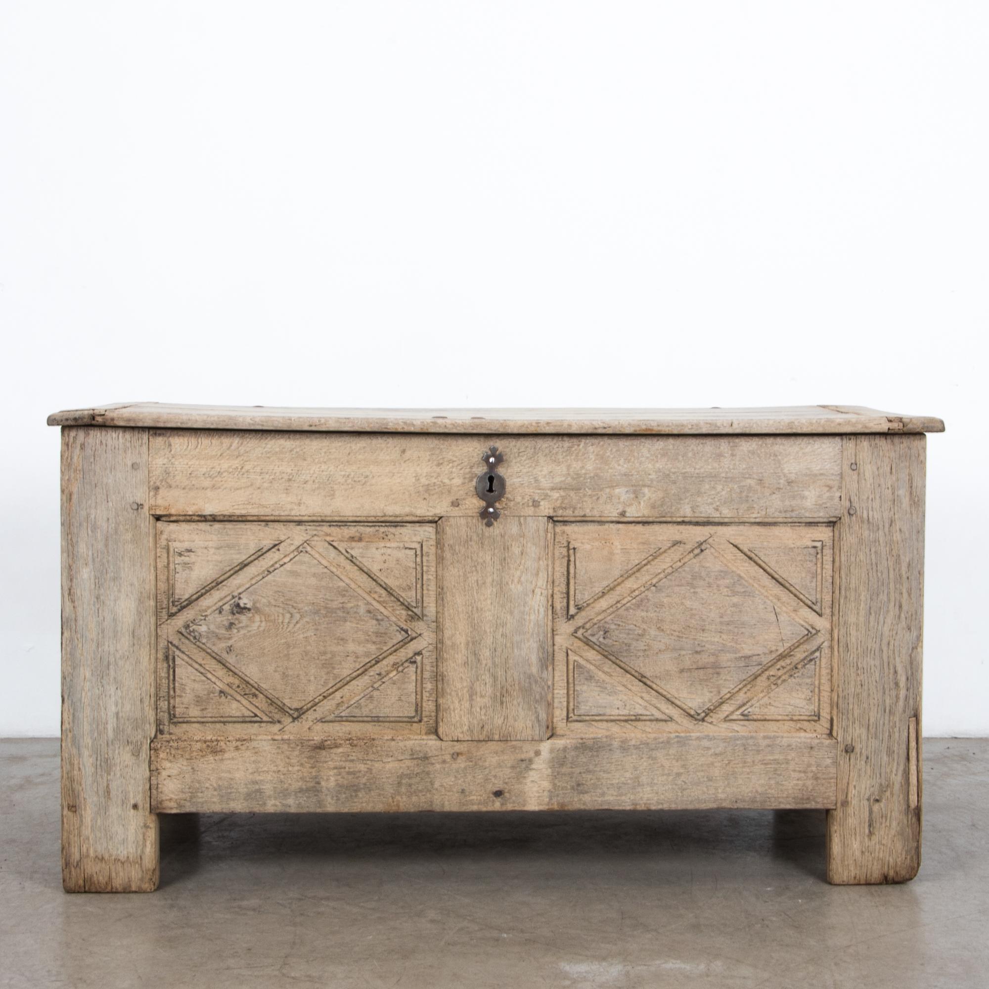 An oak trunk from France circa 1820. A sturdy construction from figured French oak is highlighted by a natural oil and wax finish. The methods of traditional craftsmen, proven by time. Featuring inside compartments, hand carved joinery, and original