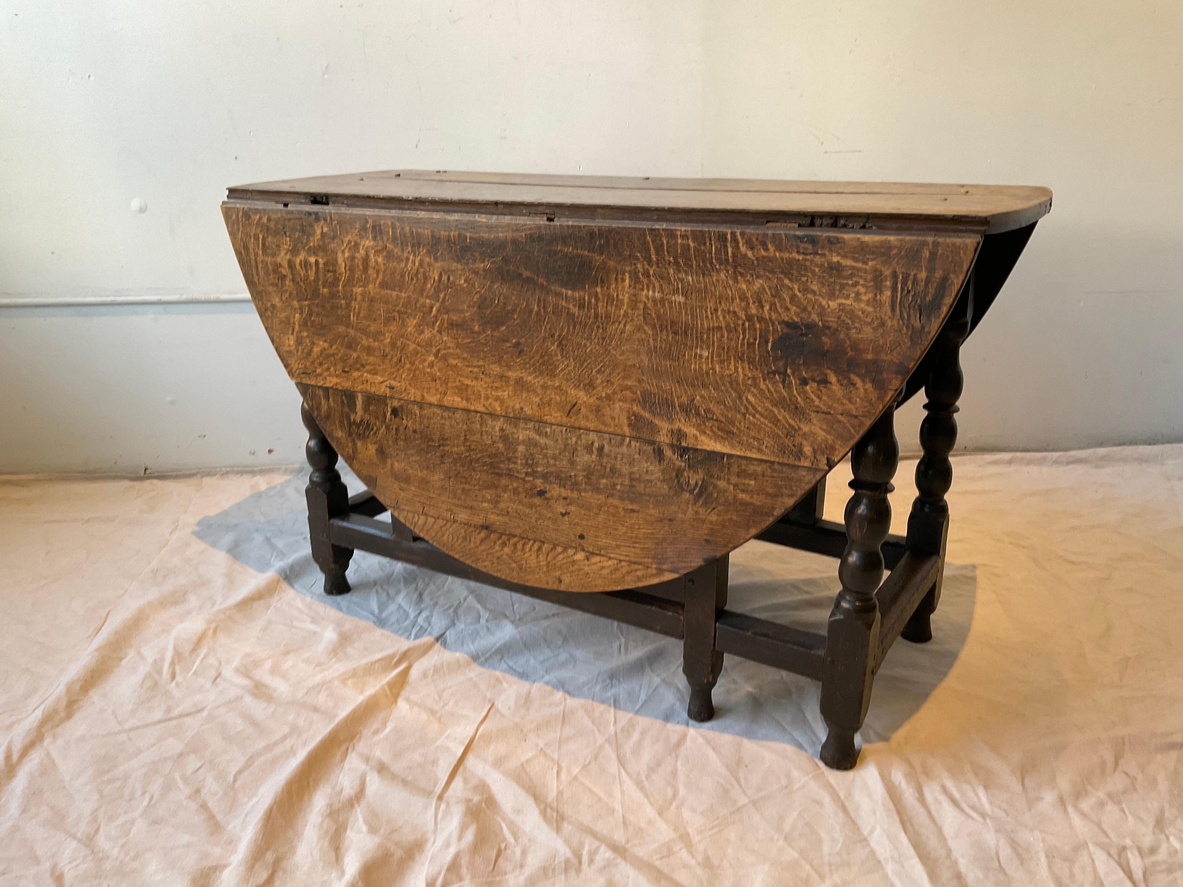 1820s English William and Mary gateleg table. Oak, pegged construction . Wood has a beautiful color to it. Very smooth. When leaves are up, width is 60.5. Depth is 48.5.