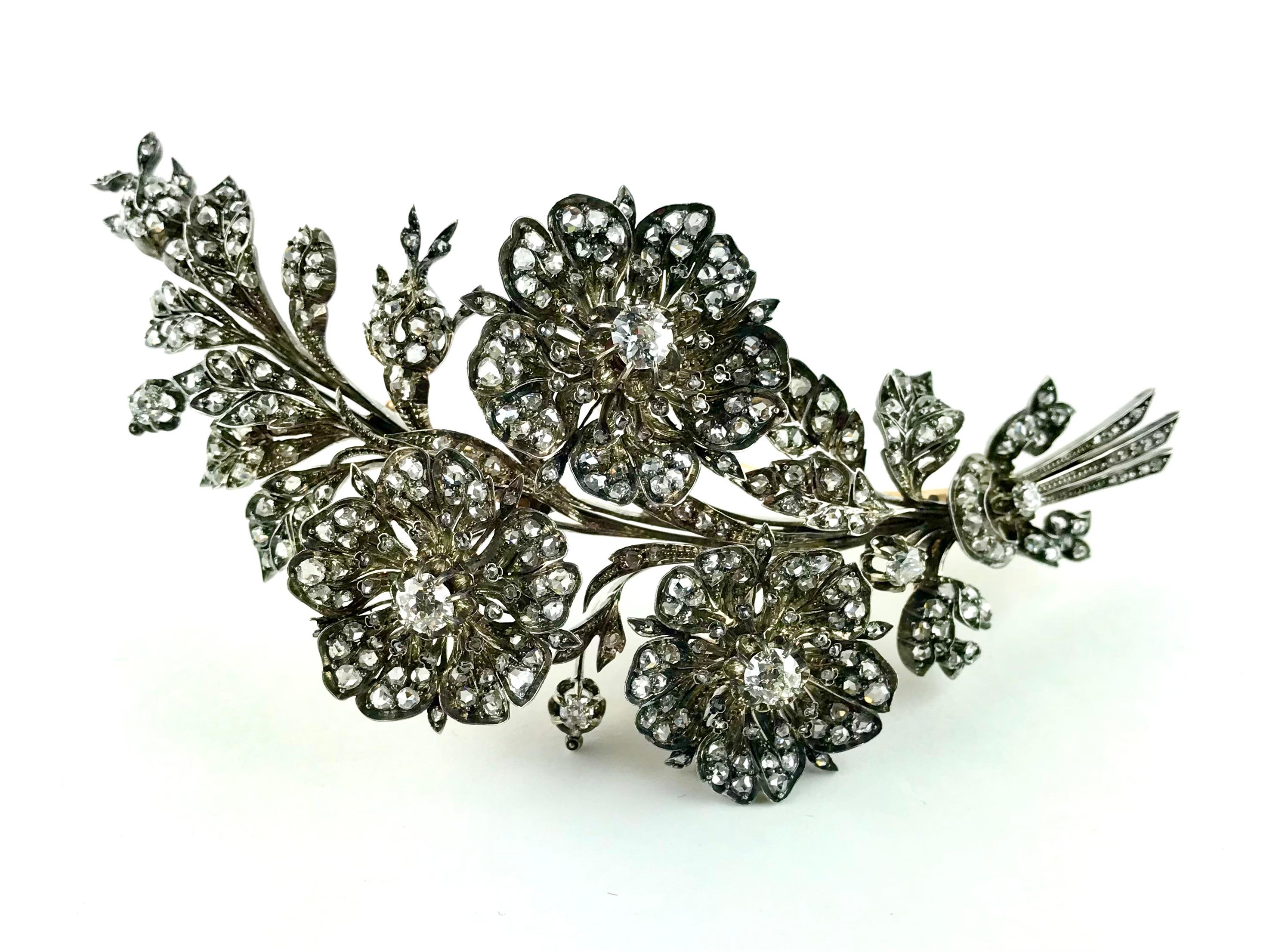 Beeindruckende und auffällige Brosche aus den 1820er Jahren mit Diamantspray, bestehend aus einem Zweig mit drei Blumen, Knospen und Blattwerk, die in Paris in 18 Karat Gold und Silber gefertigt wurde. In die Blütenblätter und Blätter dieser