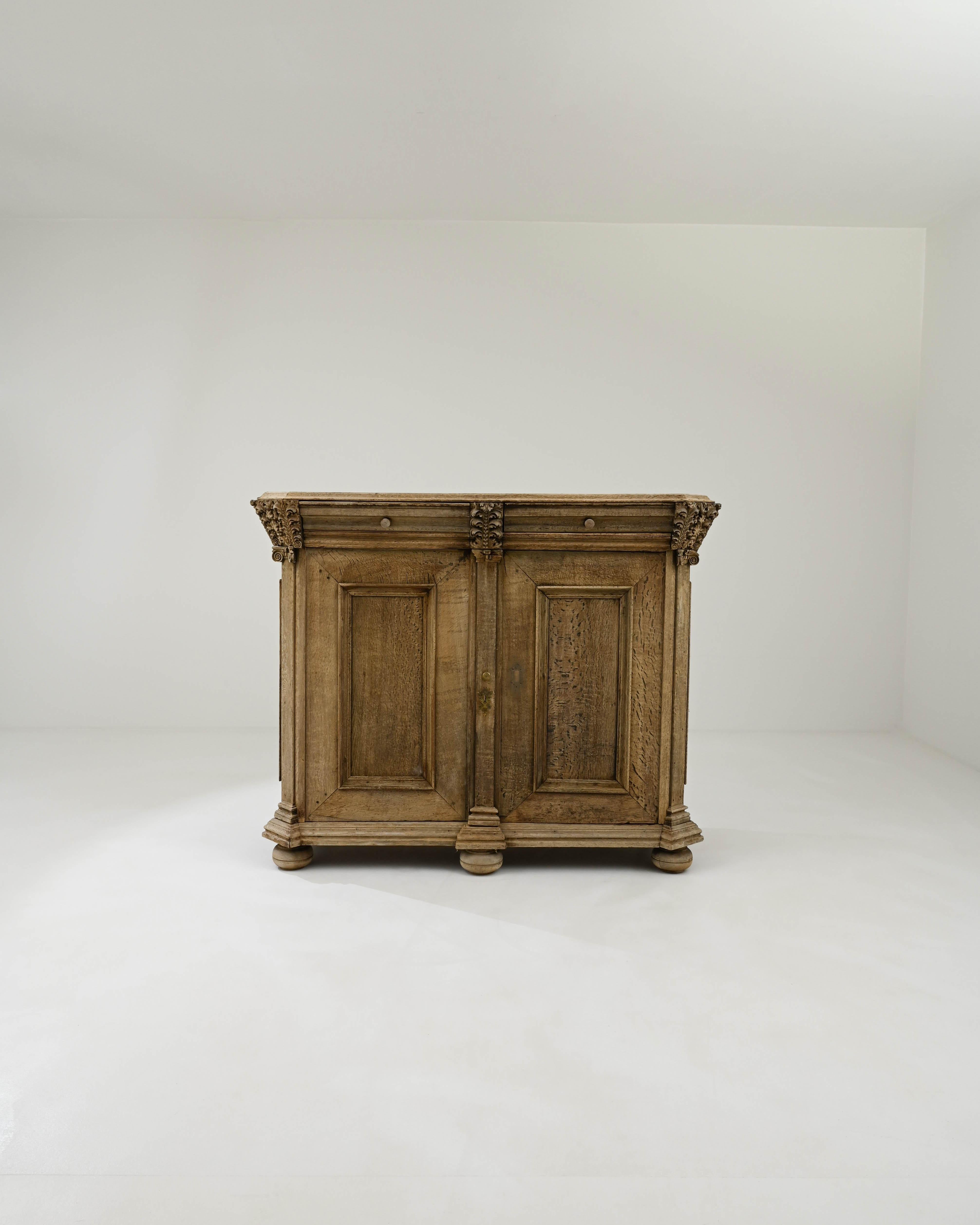 A wooden buffet created in France circa 1820. Stout and sturdily constructed, this expansive wooden buffet displays a confident design and classic 1800s French artisanry. Paneled doors, rotund and lathed feet, and fastidiously carved floral motifs