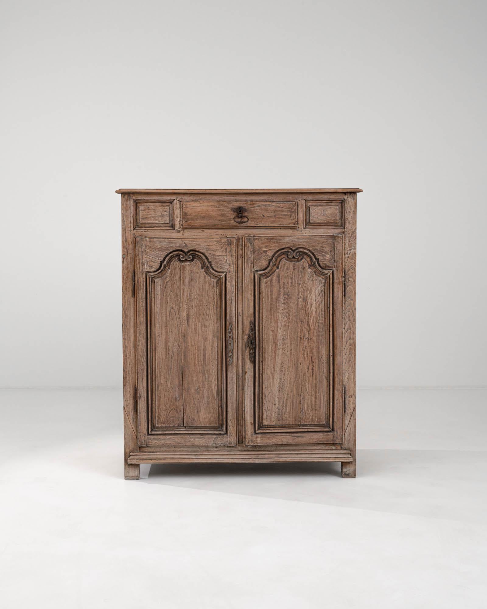 This 1820s French Wooden Buffet is a testament to timeless craftsmanship and provincial charm. Constructed from solid wood, this piece showcases the natural beauty and grain of the material, enhanced by a warm patina that tells the story of its age.