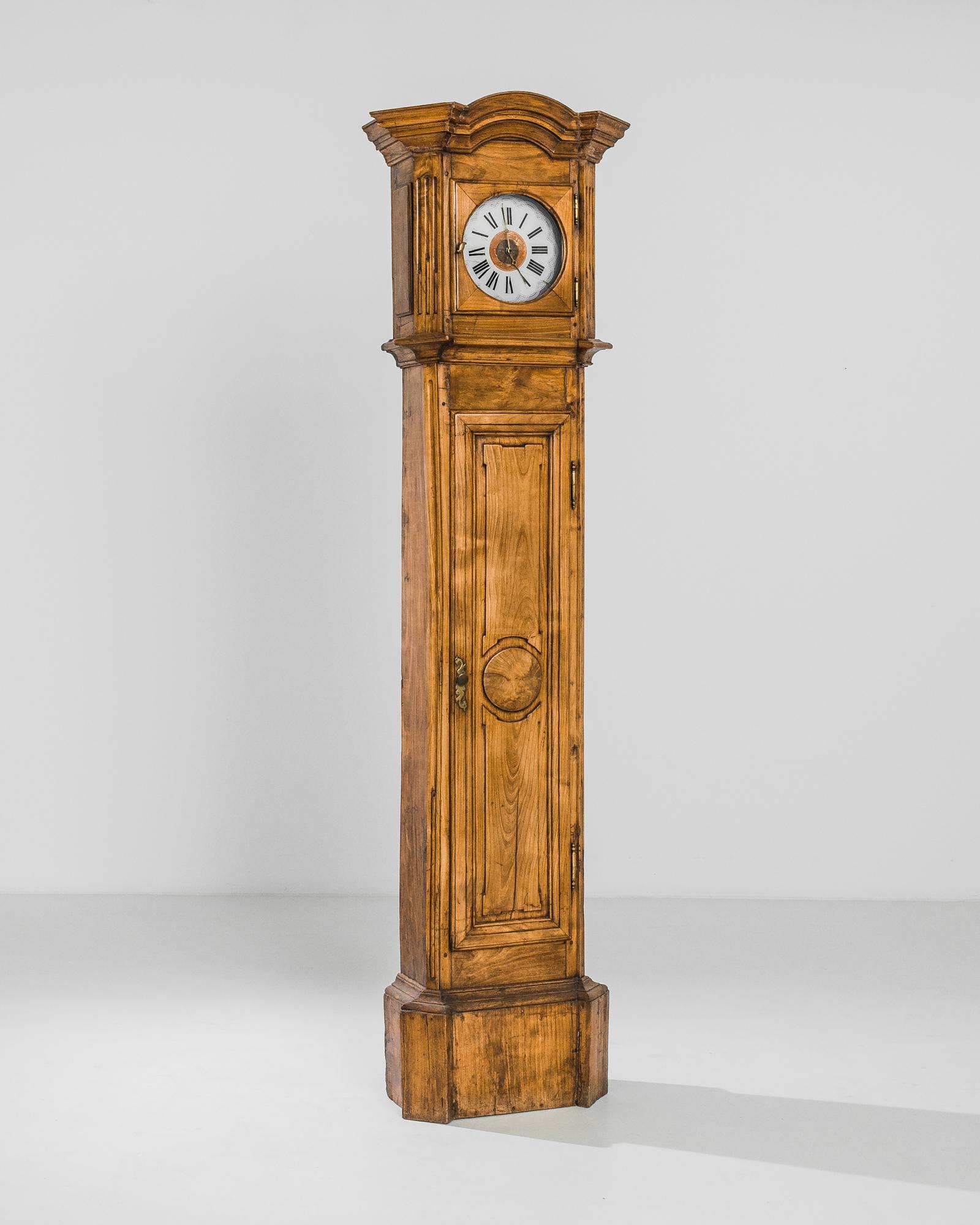 A wooden floor clock from France, produced circa 1820. Standing at an spectacular seven feet three inches, this gargantuan grandfather clock makes for an impressive timepiece. Inside the closet sit the pendulum and weight that keep this machine