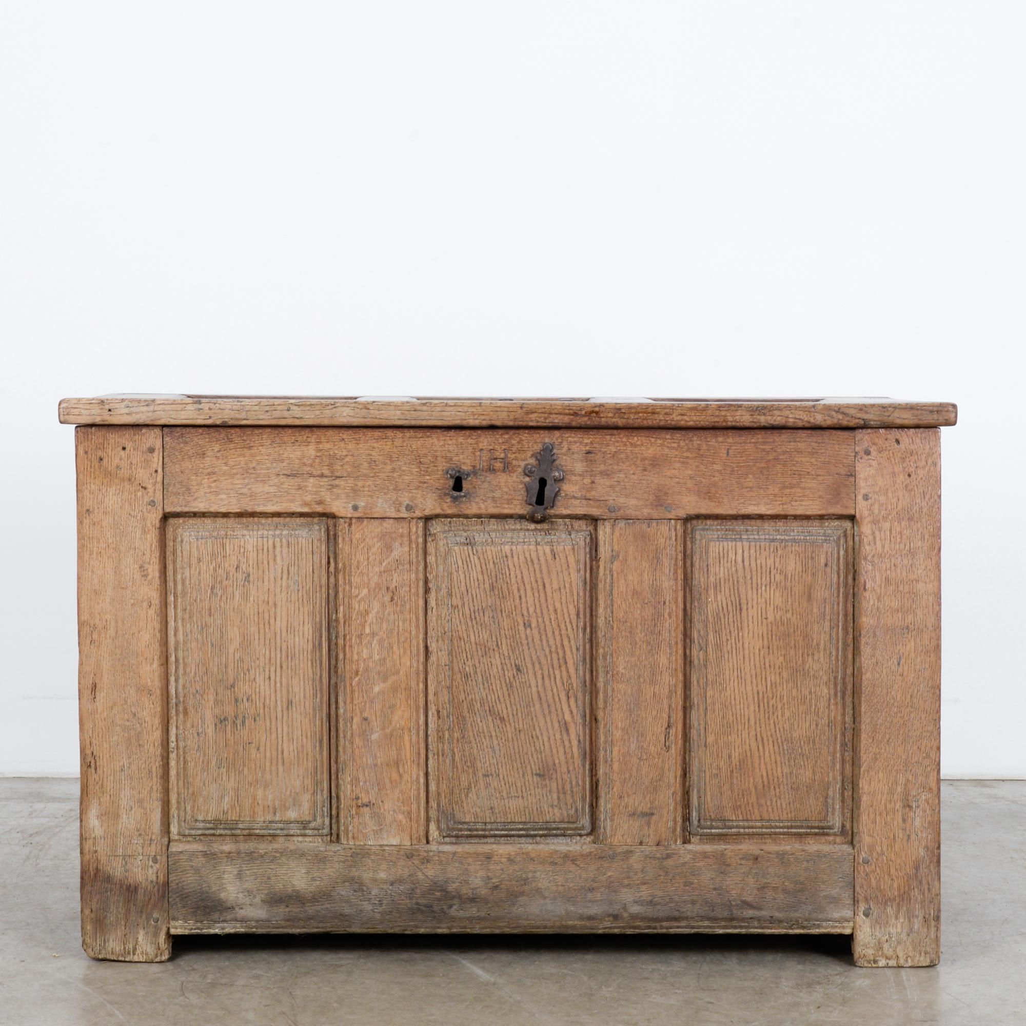 A wooden trunk from France, circa 1820. Classic rustic design with recessed rectangular panels around the sides and across the lid. Has original hinges with a new chain to hold the lid open. Features original lock with manufacturers mark stamped in