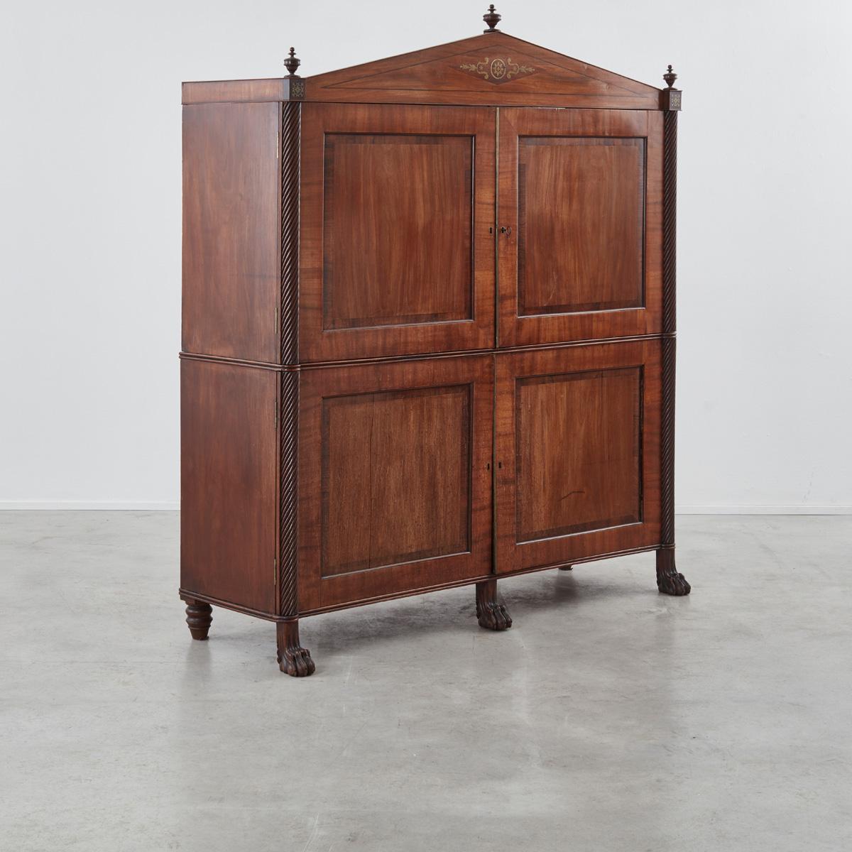 This classically inspired and elegantly proportioned wardrobe in mahogany and rosewood was crafted in Germany in the 1820. Its four hinged doors open upon several neatly designed compartmentalised spaces that now serve as shelves, having once