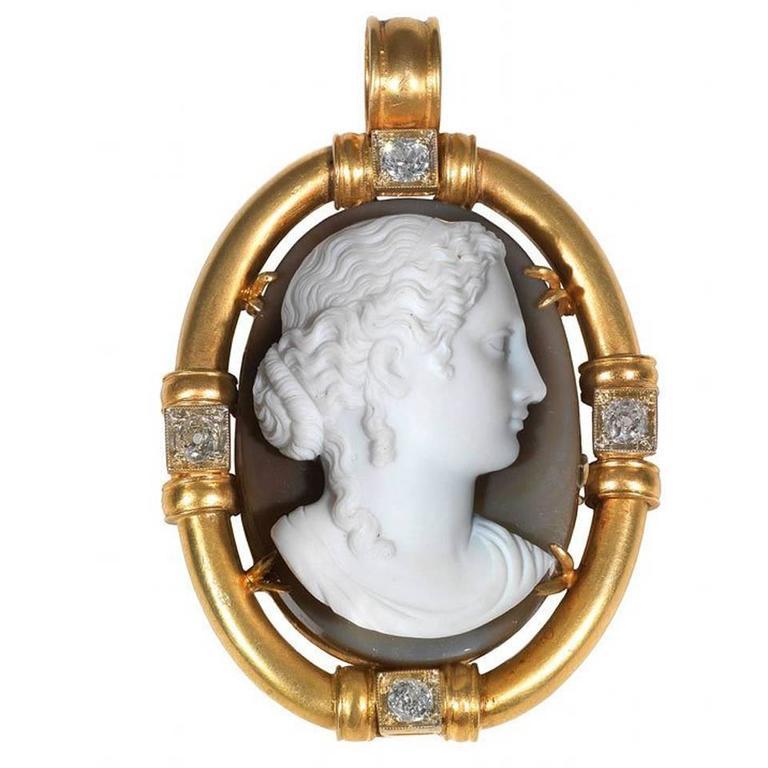 
The carved stone agate cameo depicting a female bust, measuring approximately 43.0 by 30.5 by 16.0 mm (with the frame 65 by 45 mm). 
Framed by an oval 18Kt gold mounting with 4 round old-cut diamonds weighing approximately 1.5 carats.