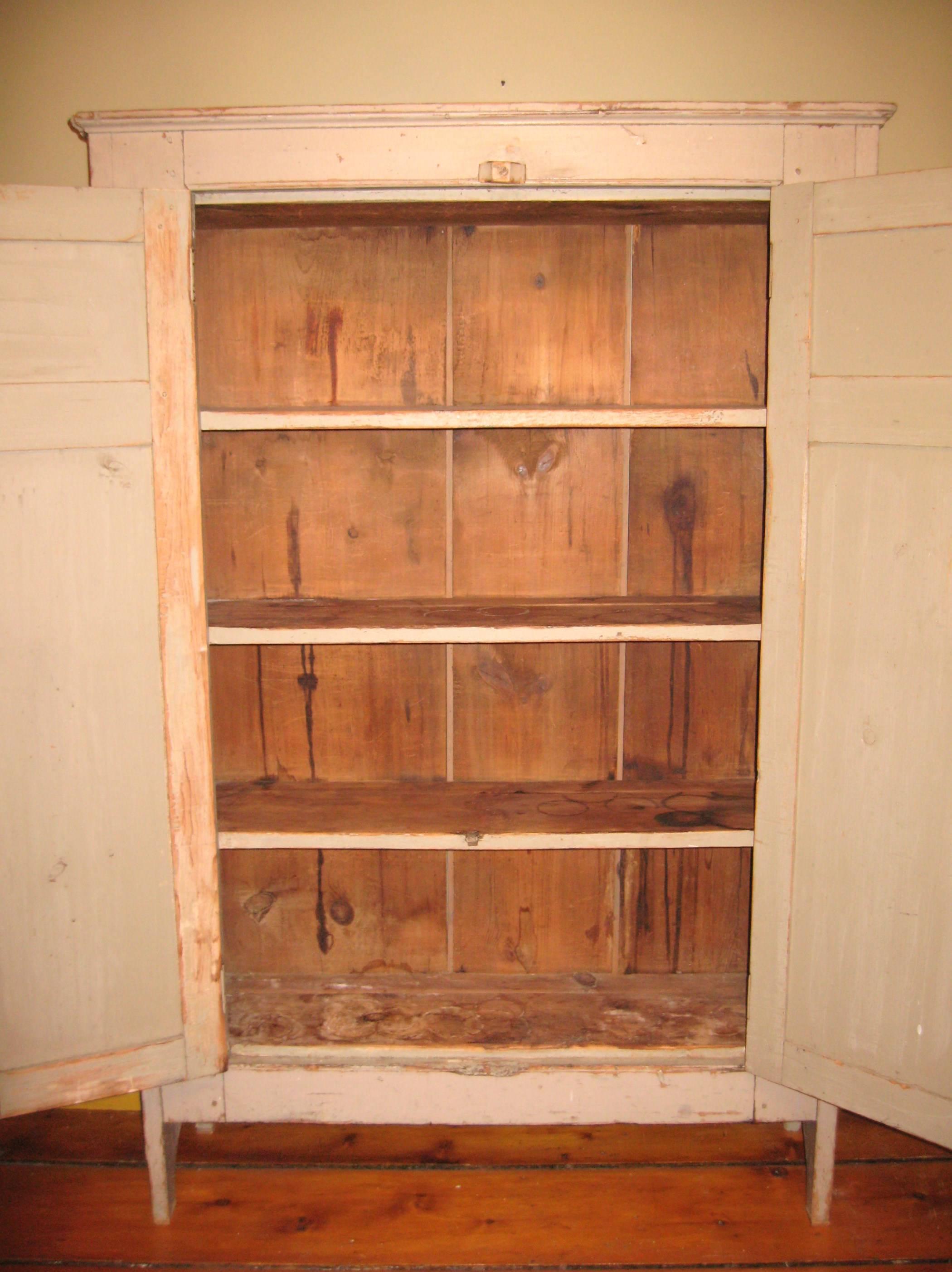Wonderful early 1800s pine two-door cupboard. Wonderful putty color that will fit in with many color palettes. Pegged construction. Fabulous original distressed look that was not just painted on. Plenty of storage space with four shelves. Original