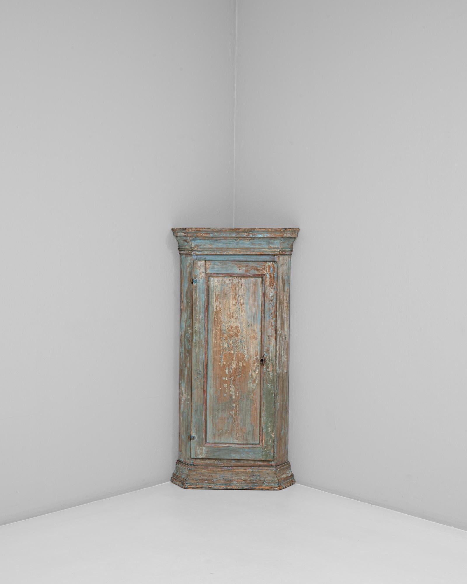 Questo mobile angolare svedese Gustavo del 1820 incarna la sobria eleganza e la simmetria del periodo Gustaviano. Realizzato in legno con l'originale patina stratificata nei toni del blu tenue e dell'ocra caldo, il pezzo mostra una finitura