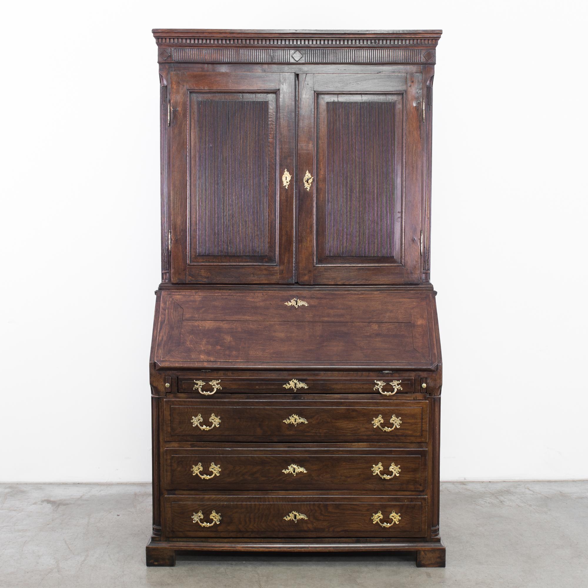 This wooden secretary desk was made in Sweden, circa 1820. Elegantly ornamented with decorative drawer pulls, the reeded paneling and lozenge reliefs display the beauty and skill of Swedish craftsmanship. A beautiful piece in oak, retains original