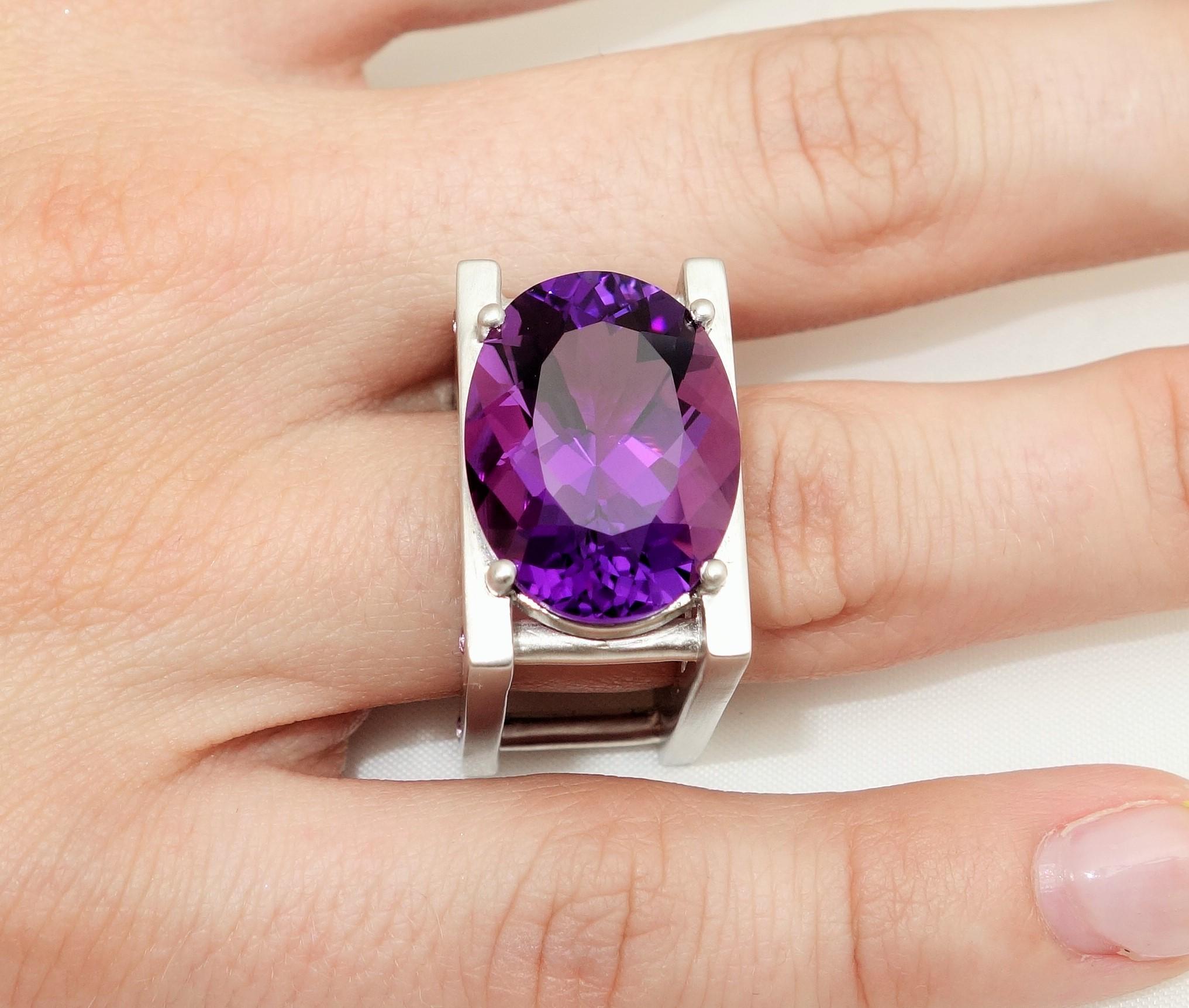 Sensational Avant-Garde Ring set with a large 18.22 Carat oval facet-cut Amethyst and 8 'rivets' set with small pink sapphires, in a unique Industrial style Sterling Silver Rhodium Tarnish-resistant mounting. More fabulous in person and so