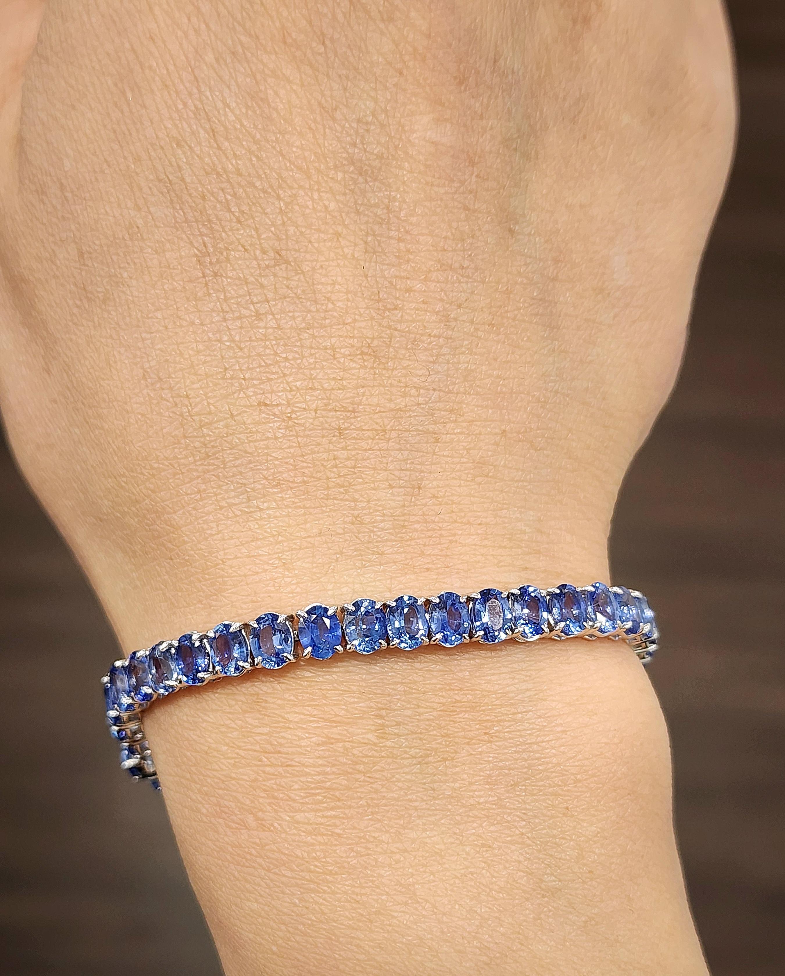 This gorgeous tennis bracelet is a stunning creation. Featuring 18.22 carats of 45 oval-cut blue sapphires, each stone is set in 18k white gold. Crafted with precision, this piece is 7 inches long and a remarkable addition to any collection.