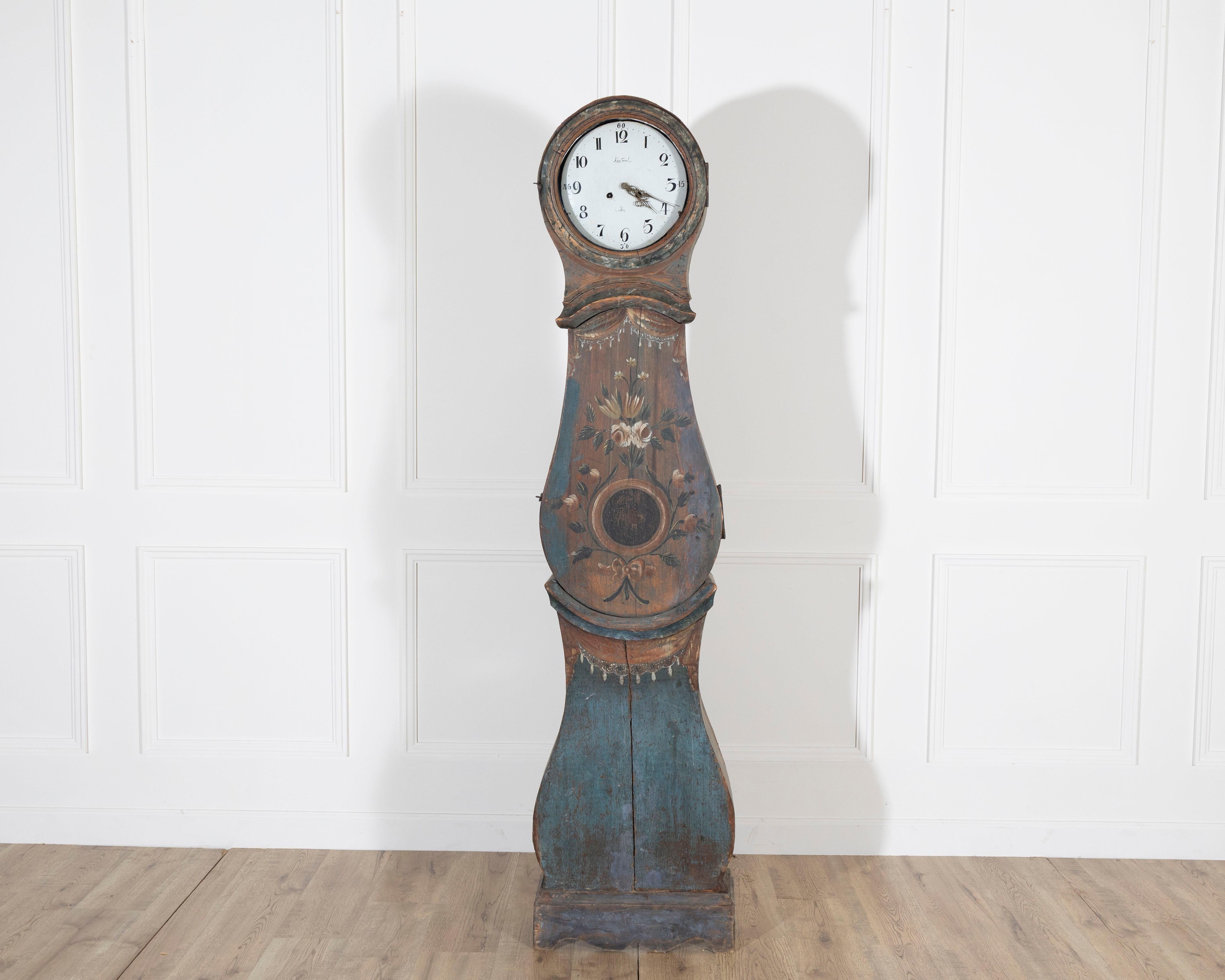 A striking example of Swedish folk art, this tall case clock dated 1822 is a celebration of craftsmanship and color. Retaining its untouched original painted surface, the case is adorned with hand-painted floral motifs in warm ochres, earthy reds,