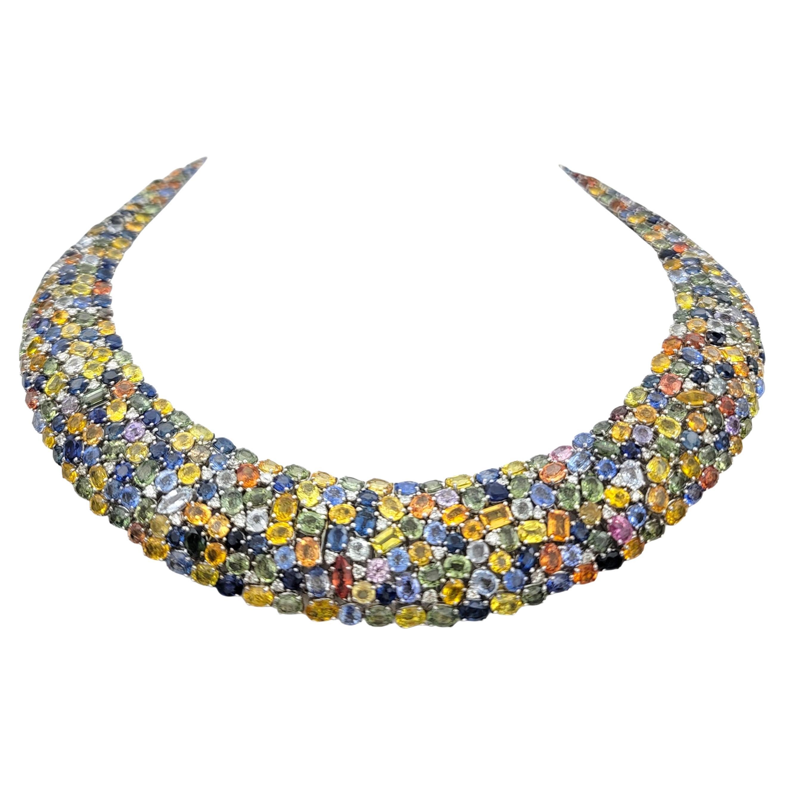 This spectacular collar necklace is a true masterpiece of color and brilliance. Crafted in 18 karat white gold, the design features an ornate, woven pattern that glimmers with an impressive display of natural sapphires in shades of blue, orange,