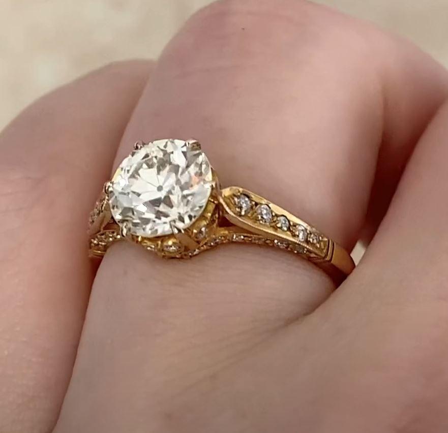 This exquisite 18k yellow gold ring showcases a stunning approx. 1.80-carat old European cut diamond, graded J in color and VS2 in clarity. The center stone exudes timeless brilliance, reflecting the craftsmanship of a bygone era. Its antique cut