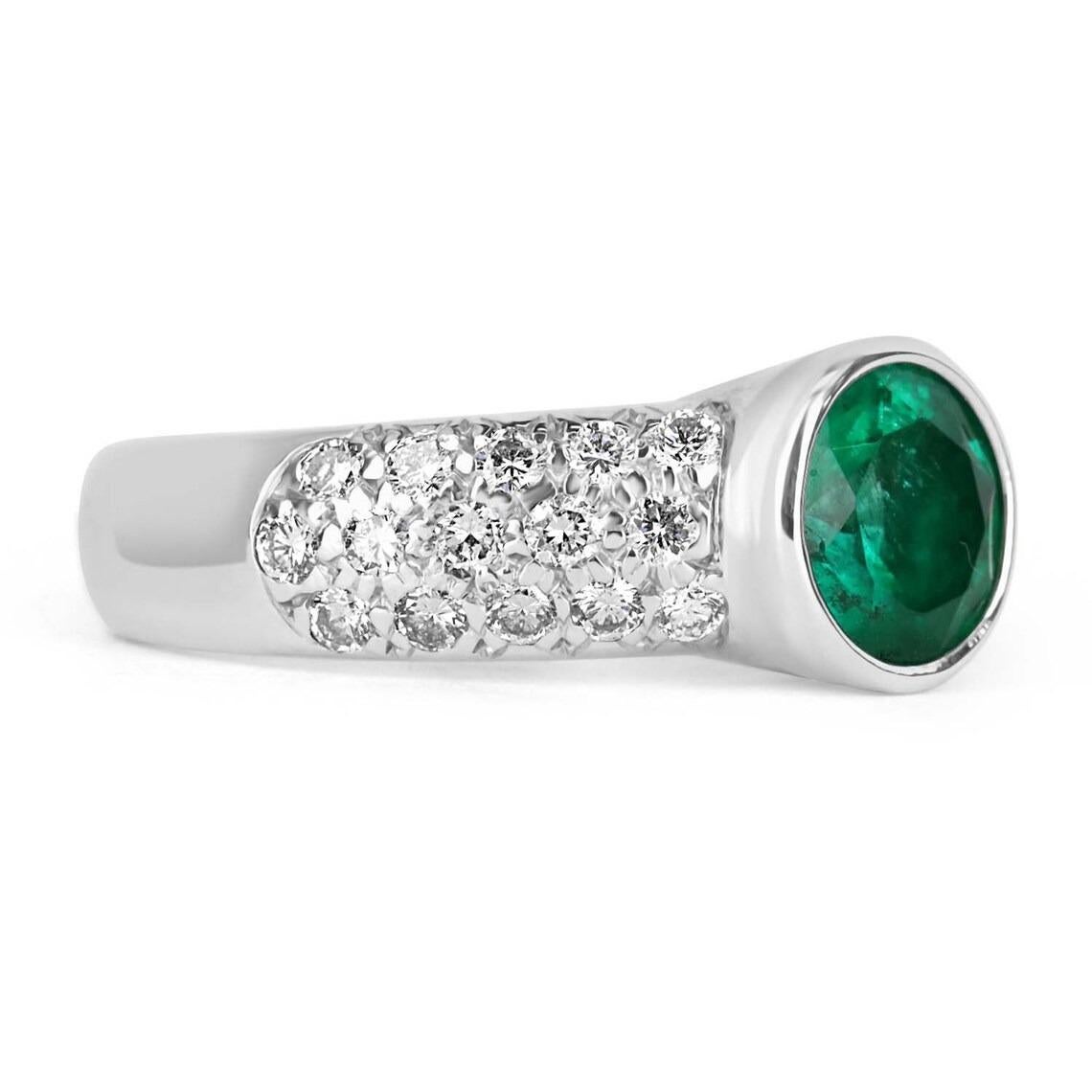 Featured is a stunning emerald and diamond statement ring. The center stone carries 1.74-carats of pure green Colombian emerald beauty. This natural gemstone is bezel set and displays a gorgeous vivid green color, excellent luster, and triple-A