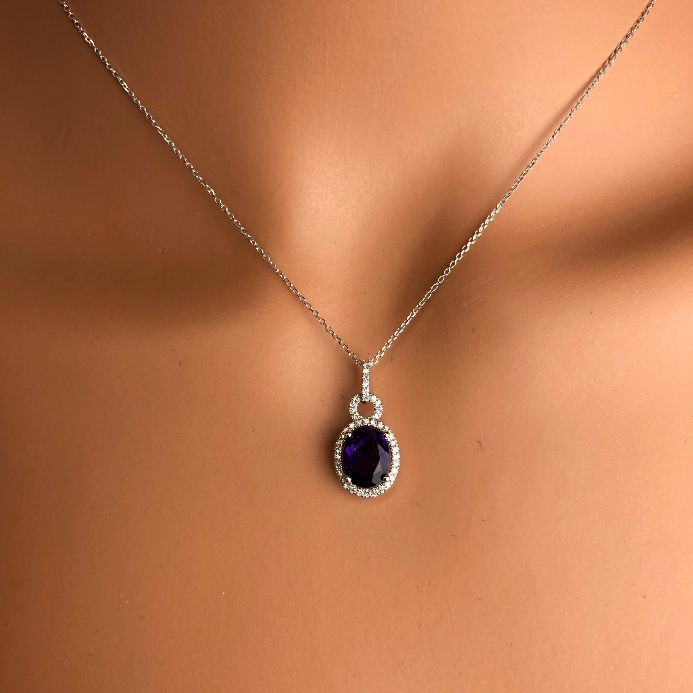 This lovely halo pendant features 1.83 carats oval cut fine Amethyst, surrounded by a halo of round white diamonds, with additional diamonds decorating the bail.

Center: 1.83 carats fine Amethyst
Diamond Halo and Bail: 43 round diamonds total 0.16