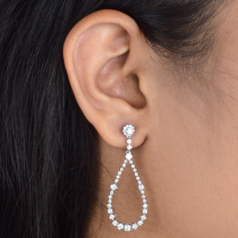 Ces boucles d'oreilles ont été méticuleusement confectionnées en or 10 carats et serties de 1,83 carats de diamants étincelants. Disponible en or blanc, rose et jaune

La bague est de taille 7 et peut être redimensionnée en plus grand ou plus petit