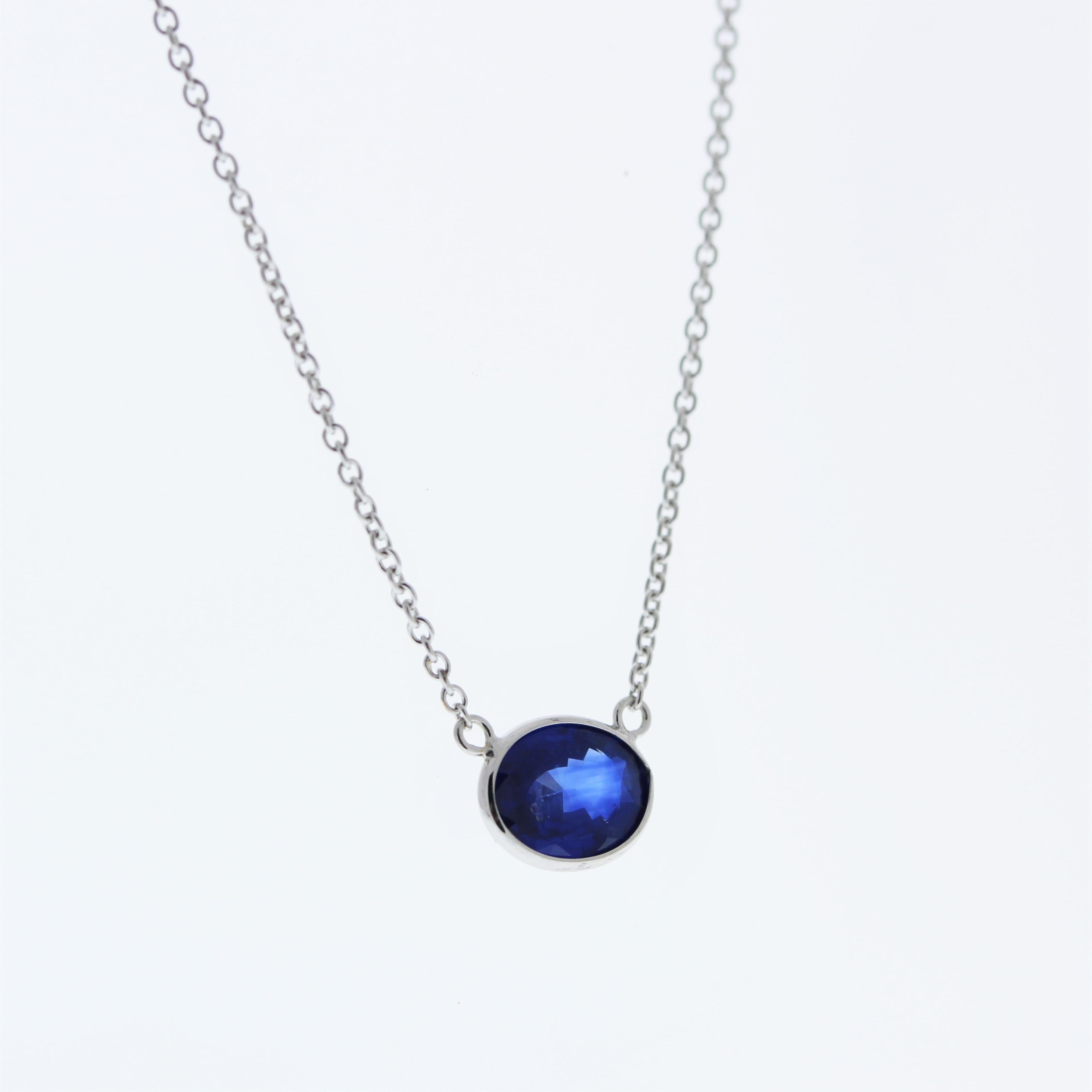 The necklace features a 1.83-carat oval-cut blue sapphire set in a 14 karat white gold pendant or setting. The oval cut and the blue sapphire's color against the white gold setting are likely to create an elegant and striking fashion piece, suitable