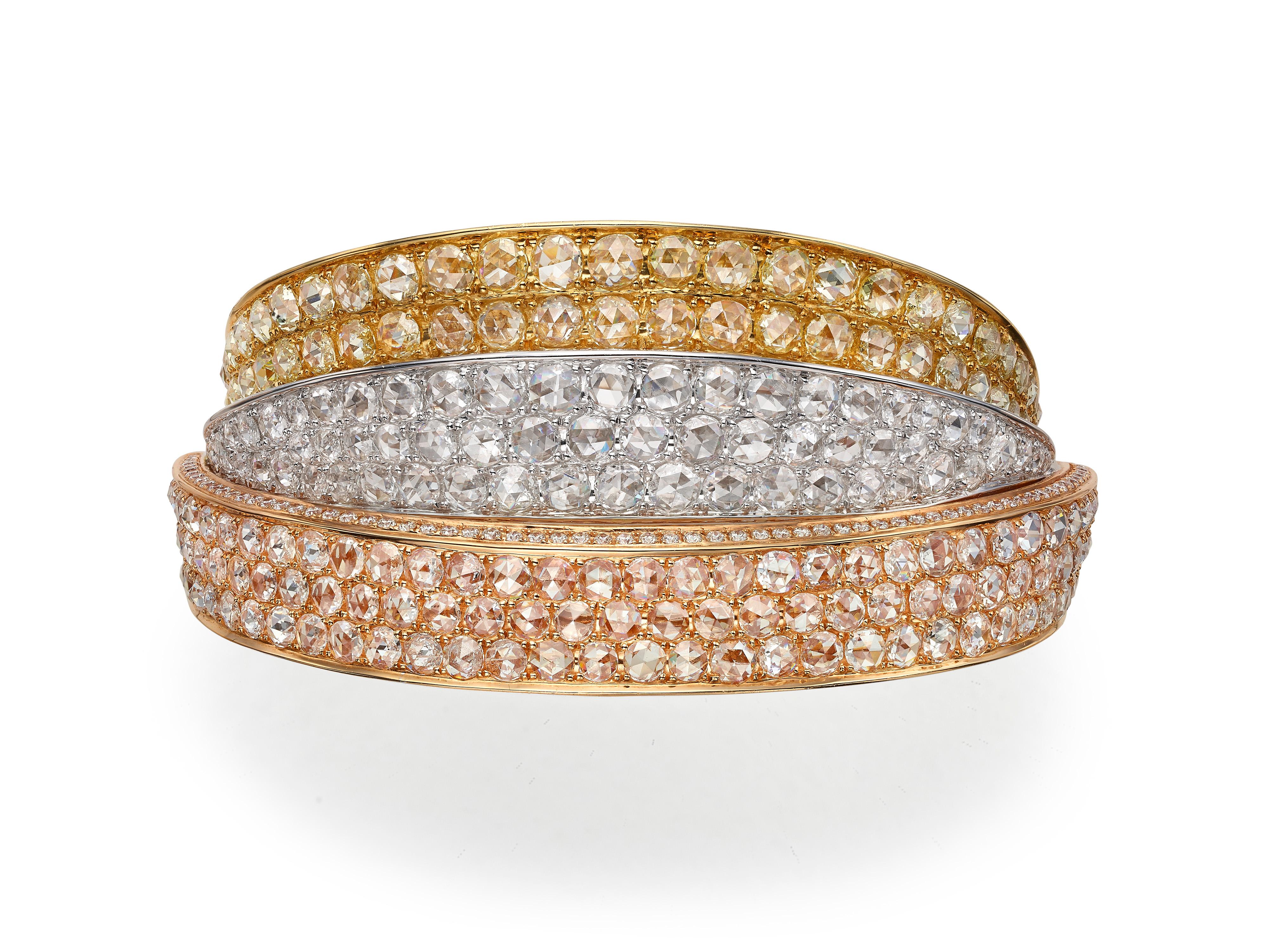 A statement cuff bangle composed of three interlocking tricolor gold panels in white, yellow and rose gold (all 18K) and pave-set with 18.30 rose cut and round white and yellow diamonds.  

Composition: 
18K White, Yellow and Rose Gold
161 Rose Cut