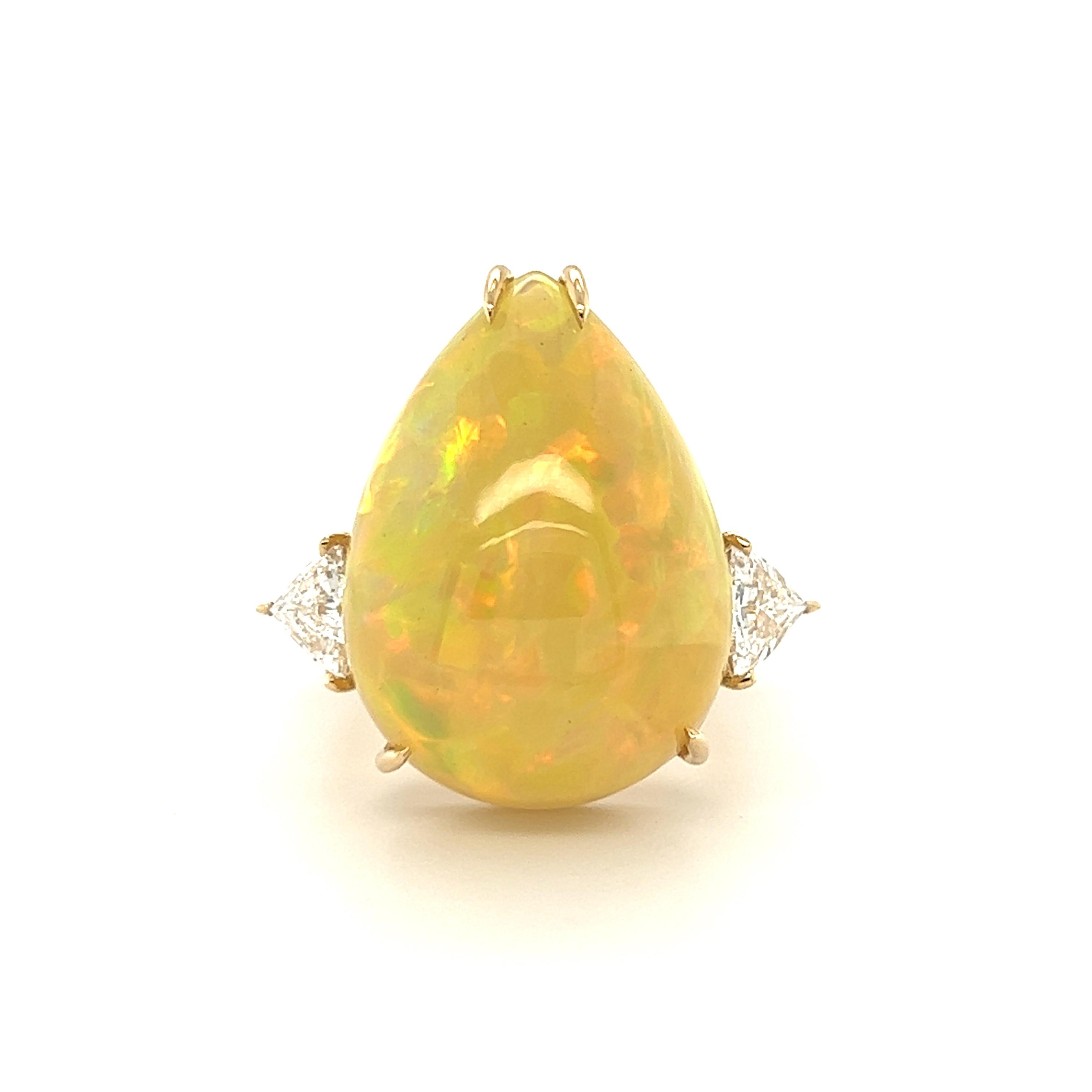 Beautiful Pear shape Fire Opal weighing 18.30 Carats flanked by Triangle diamonds weighing 1.11 carats. 

Set in 18 Karat Yellow Gold. 
Finger size 7