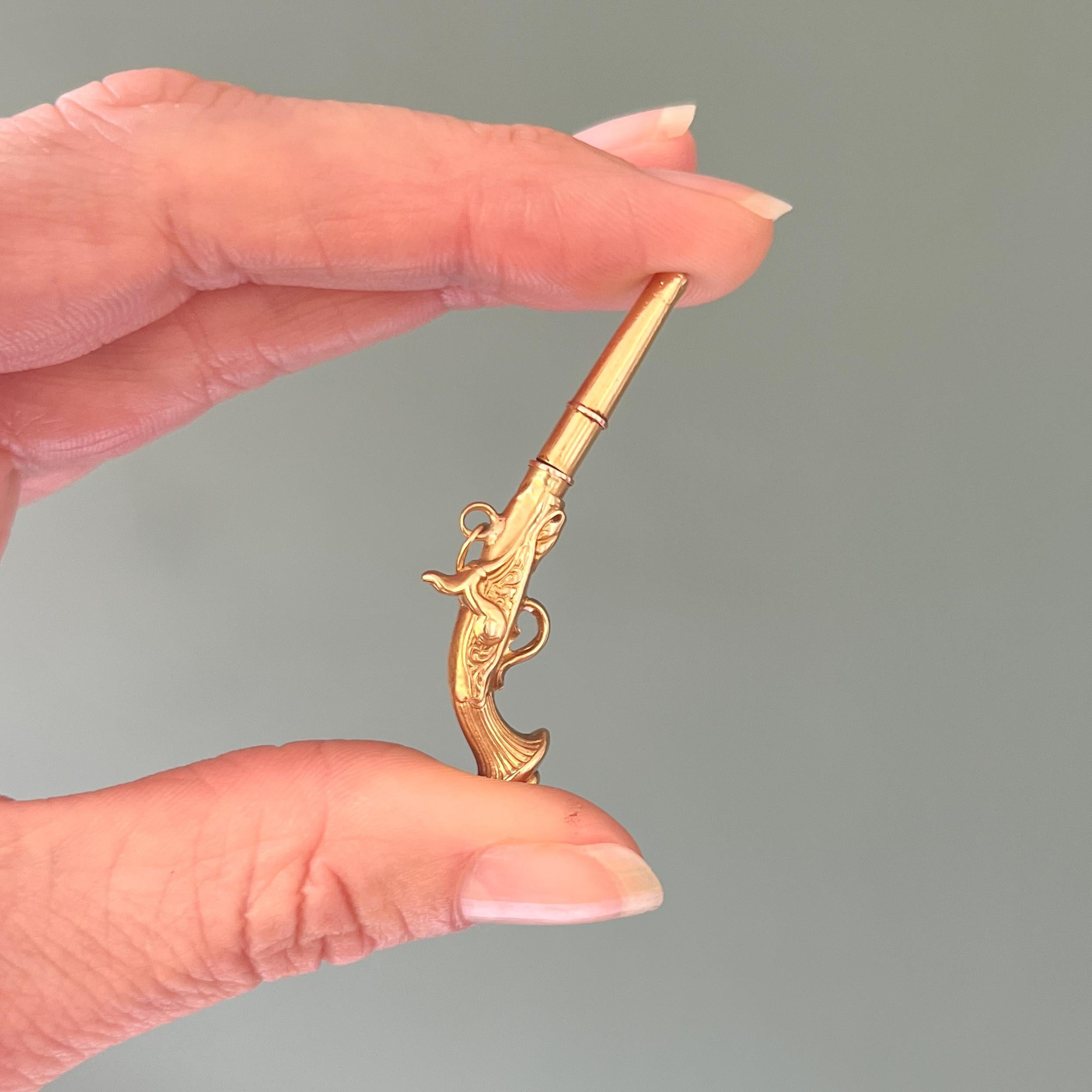 Vittoriano Ciondolo a forma di chiave di orologio da tasca in oro antico con revolver a pietra focaia in vendita