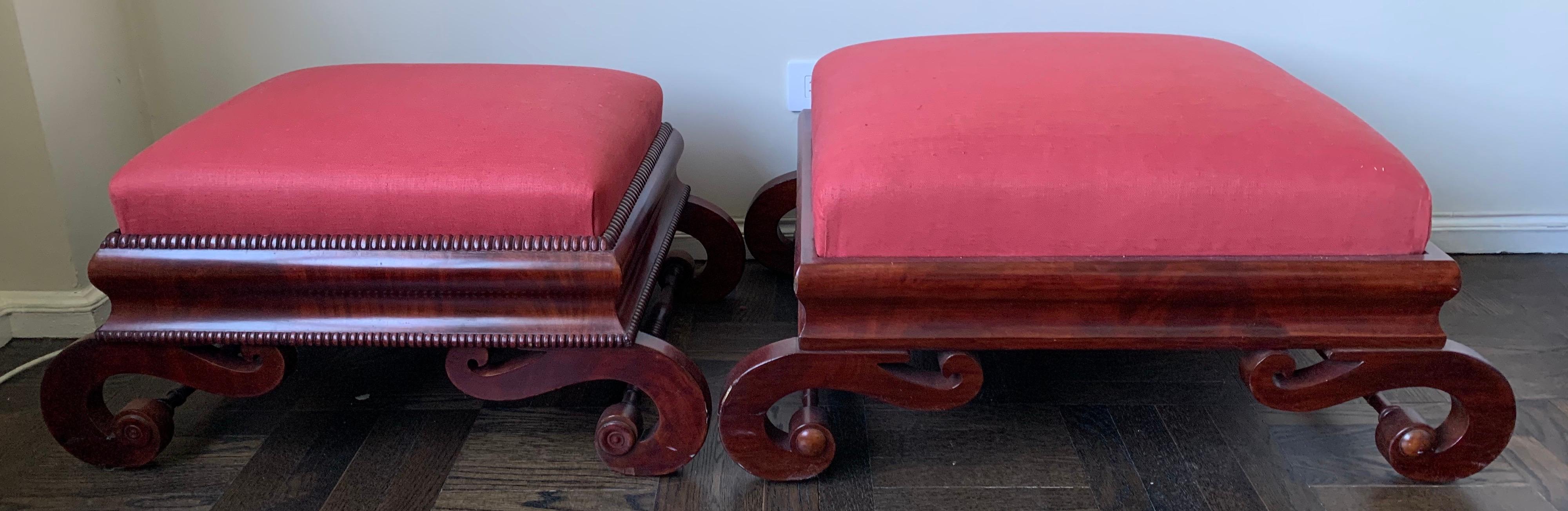 Set of 2 large carved mahogany Curule base footstools, Boston, 1830s. Recently reupholstered in red Scalamandre linen fabric. Larger stool is 32.5” wide x 24” deep x 16” tall.
Smaller stool is 29” wide x 19” deep x 14.5” tall.