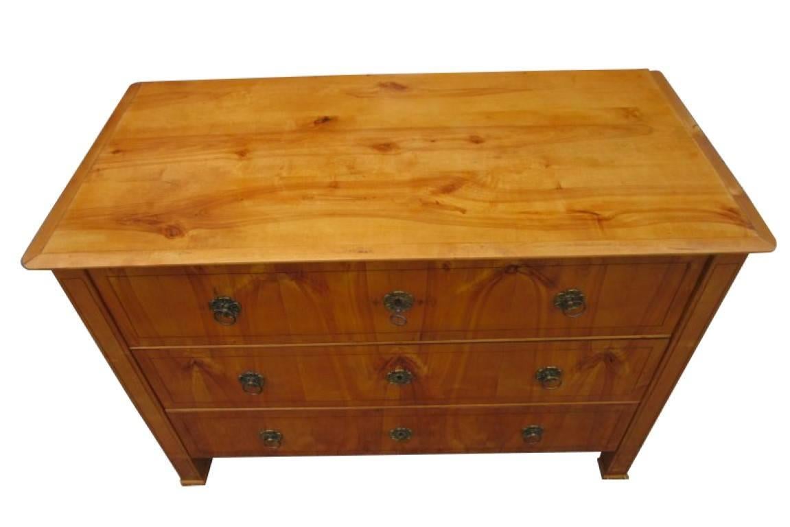 A big Biedermeier commode from circa 1830. The piece is in a perfect and restored condition. The corpus is made of fruitwood which has a wonderful light brown color and a unique grain. Three drawers hold much space for storage purposes. The front of