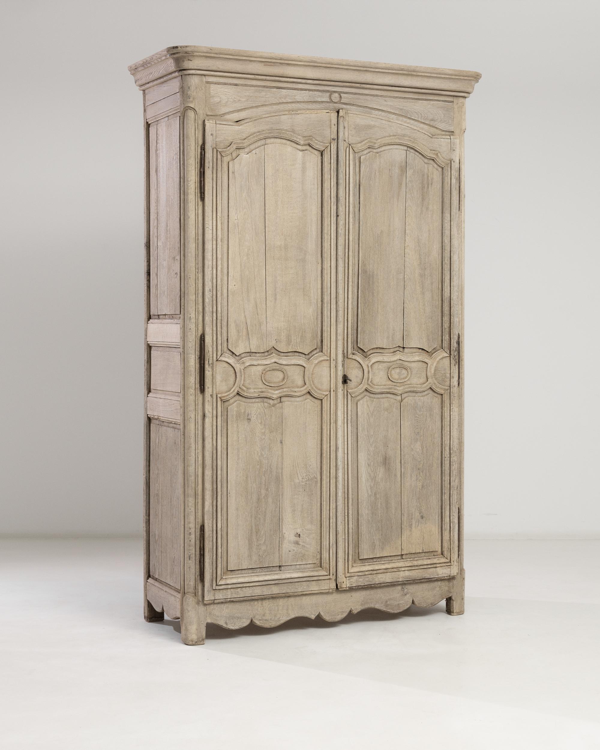 From the crown molding, the carved semicircular arch, to the bold neoclassical carvings of the raised doors and the scalloped skirt adorning the bottom — this majestic cabinet built in France circa 1830 presents a harmonious plexus of smooth