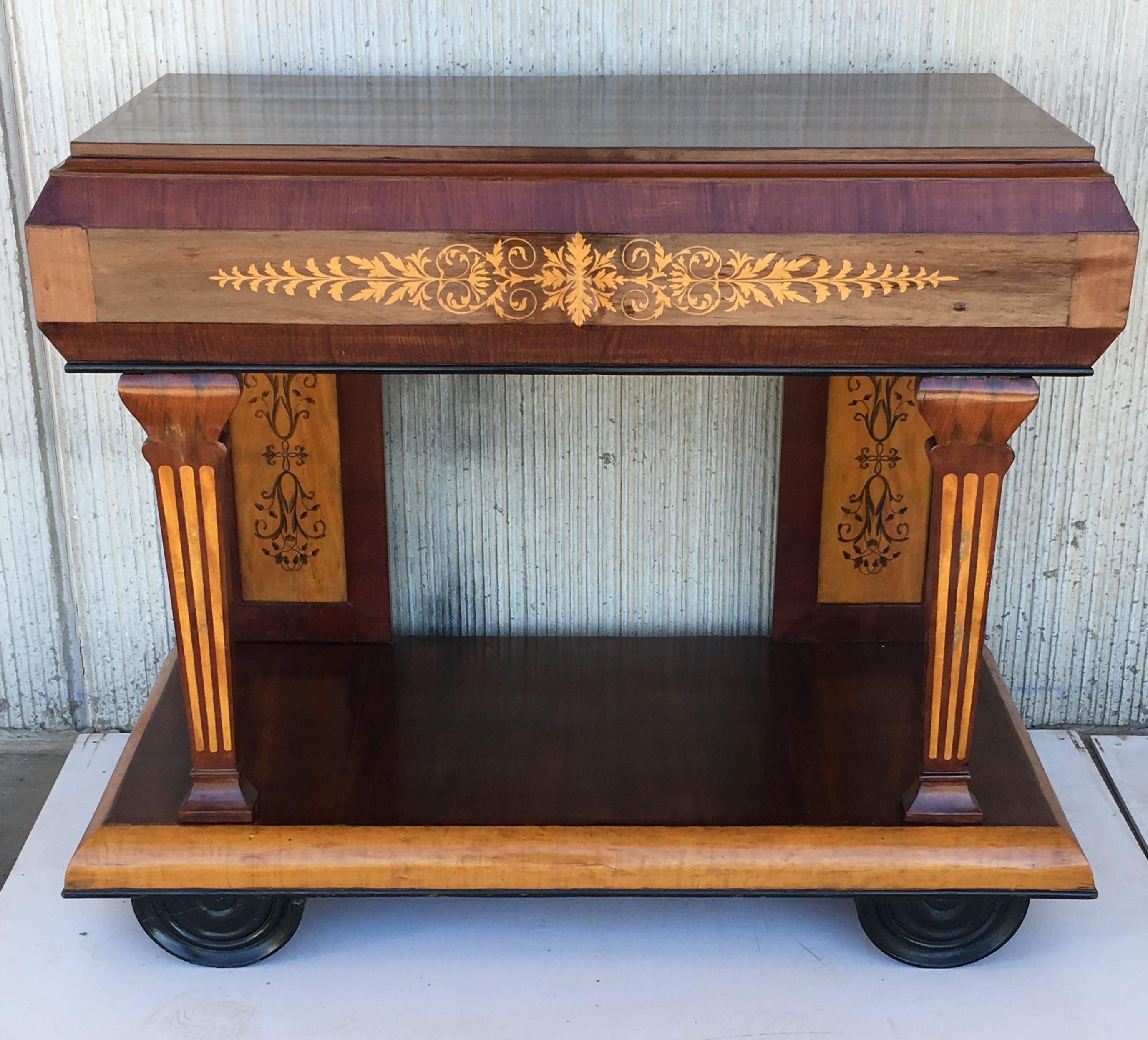 Early 19th century console in rosewood and maple. It features beautiful marquetry of rinceaux and floral motifs. It is resting on two straight legs in the back and two front columns legs. The console is set on a large base .
Charles X period.