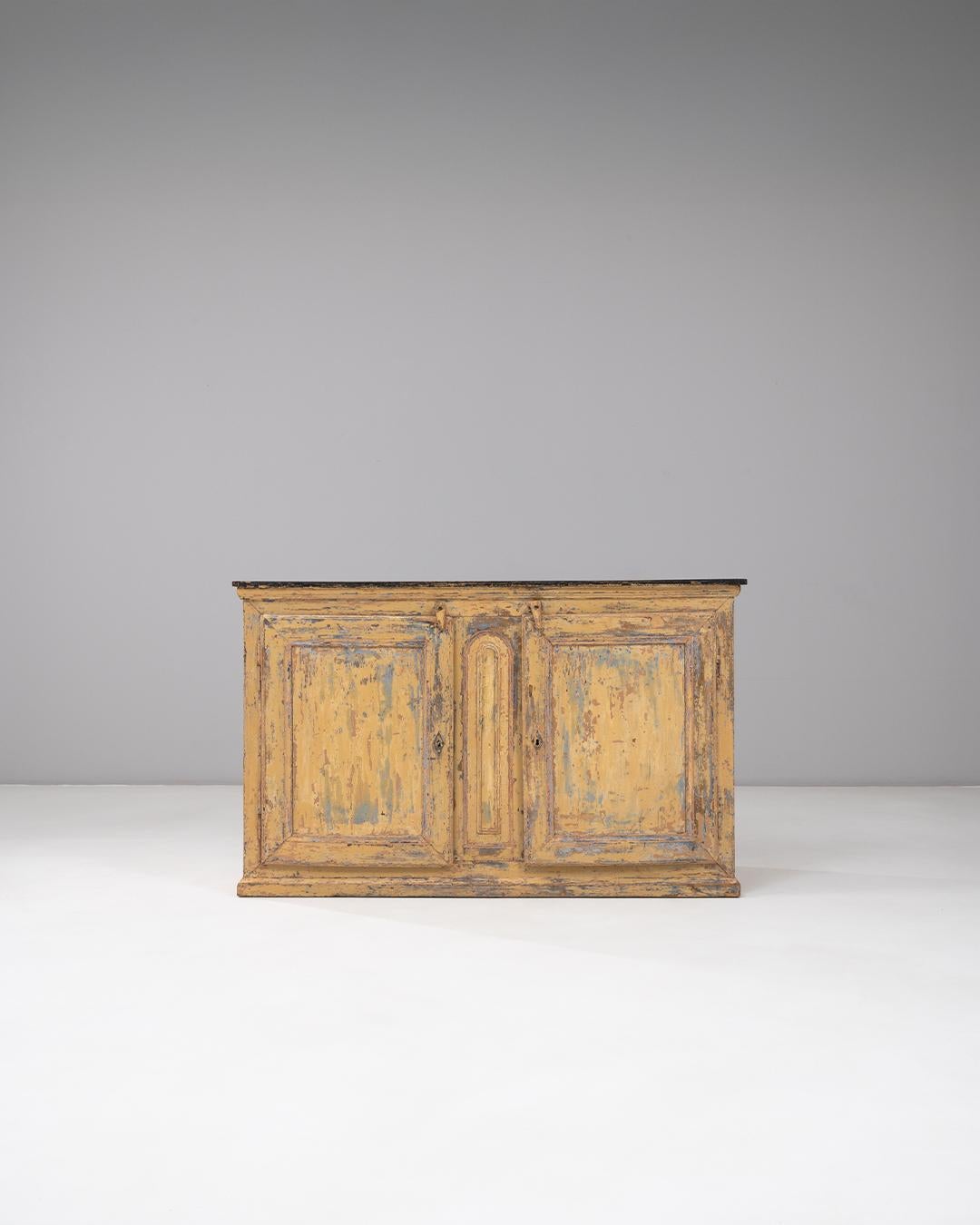 Questo buffet a due ante in stile provinciale francese del 1830 presenta una finitura patinata splendidamente invecchiata che riflette quasi due secoli di utilizzo e carattere. Le tonalità calde e pastose del legno sono esaltate da strati di vernice