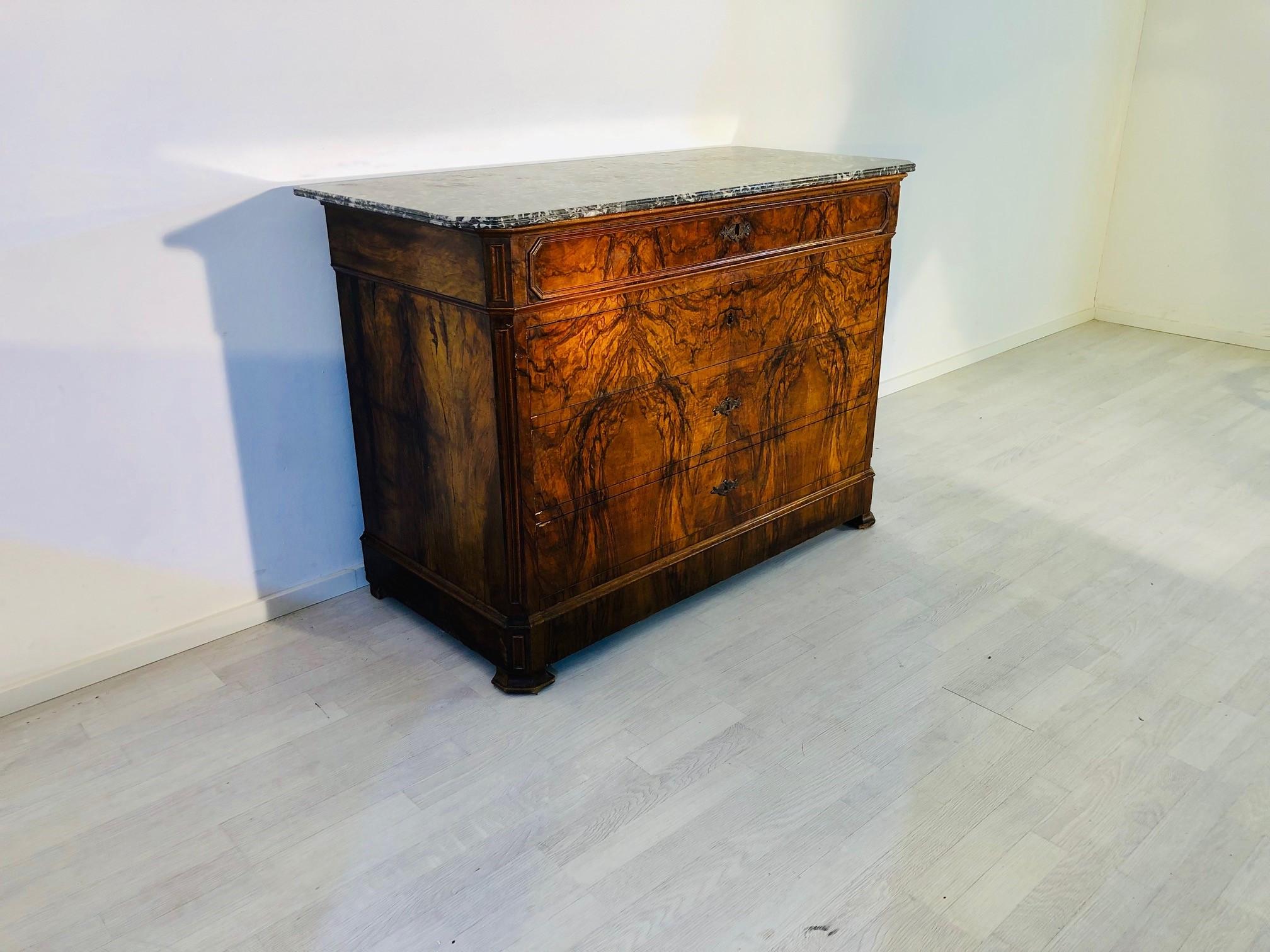 Luxurious Biedermeier era chest of drawers or commode with a medium brown and wonderfully colored walnut wood and original marble top! A stunning, eyecatching piece with a carfully selected veneer picture which extends over all four drawers. Offer