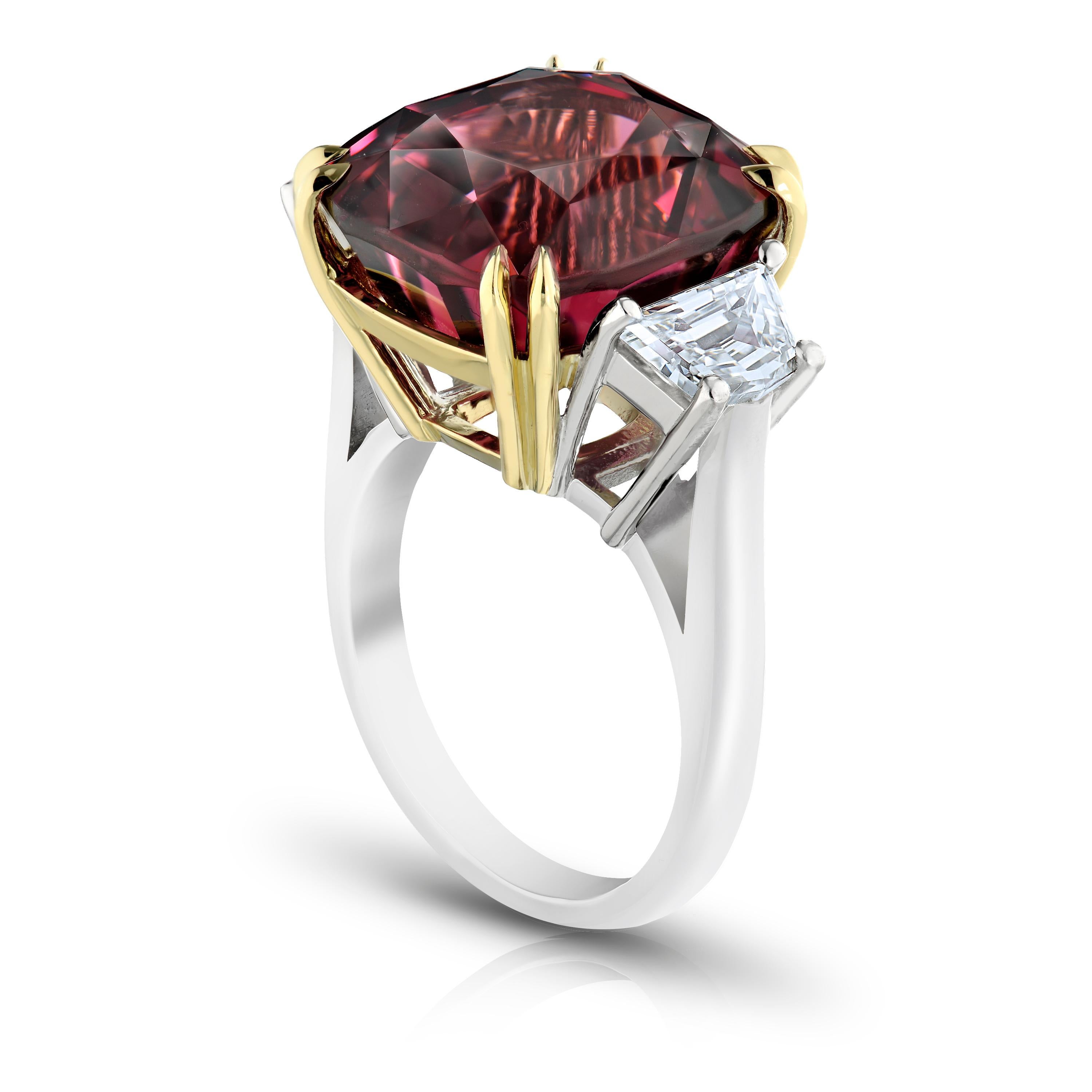 18.37 carat cushion red spinel with two trapezoid  shaped diamonds weighing 1.35 carats set in a platinum and 18k yellow gold ring. This natural no heat spinel has a gem report from C Dunigare stating that its origin is from Burma. The stone is cut