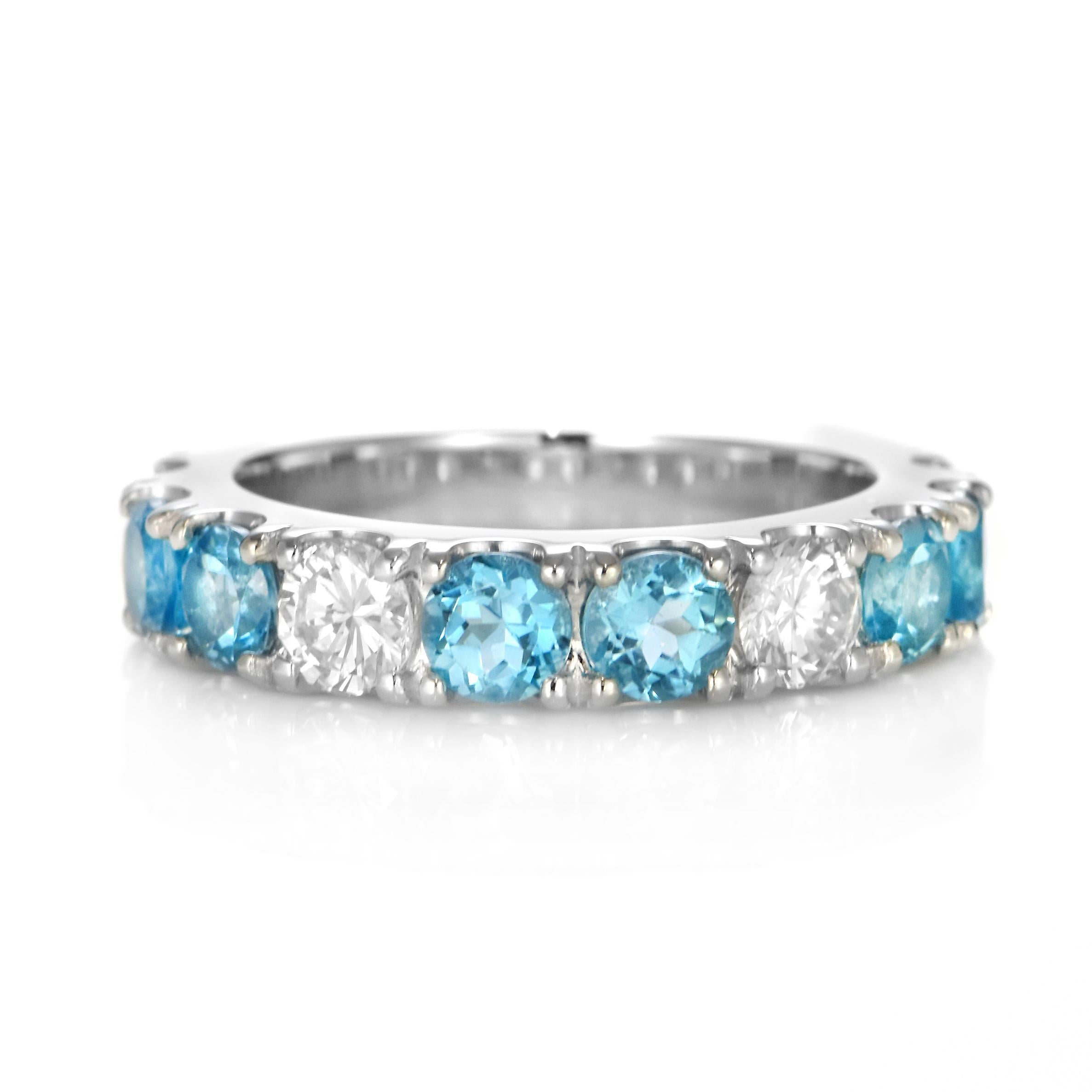 A beautiful half eternity ring featuring 1.84 Carats of Blue Topaz and 0.998 Carats of Diamond Accents set in Platinum. Topaz occurs in a broad color range that includes various tones and saturations of red, pink, purple, yellow, orange, and brown,