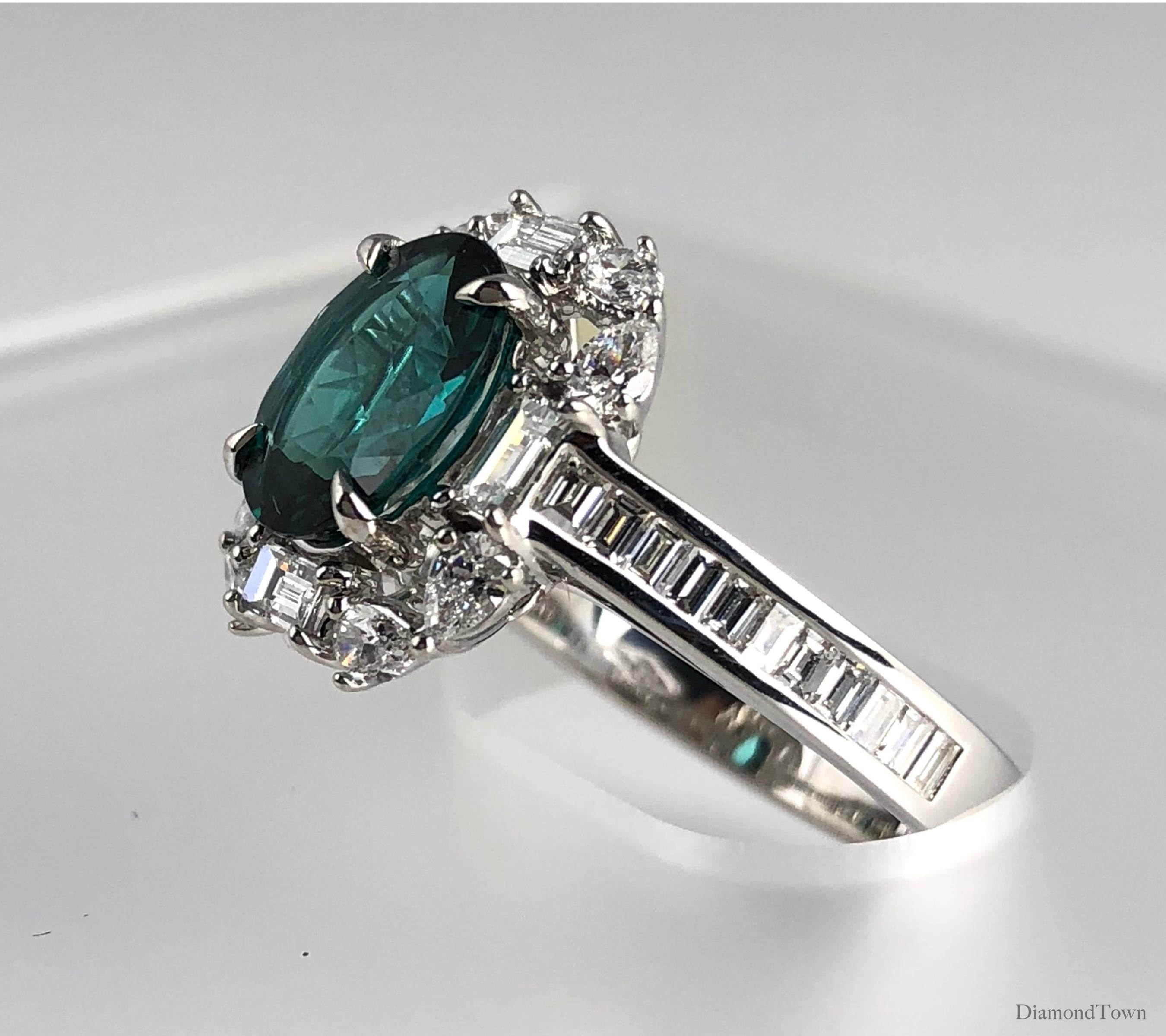This handcrafted cluster ring features a 1.84 carat Exotic Green Tourmaline oval center, surrounded by a halo of white diamonds, and additional baguette diamonds trailing down the side shank. The total diamond weight is 1.19 carats.

Ring size 6.75,