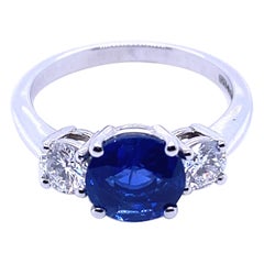 Anello di fidanzamento in platino con tre pietre, zaffiro del Kashmir e diamante da 1,84 carati