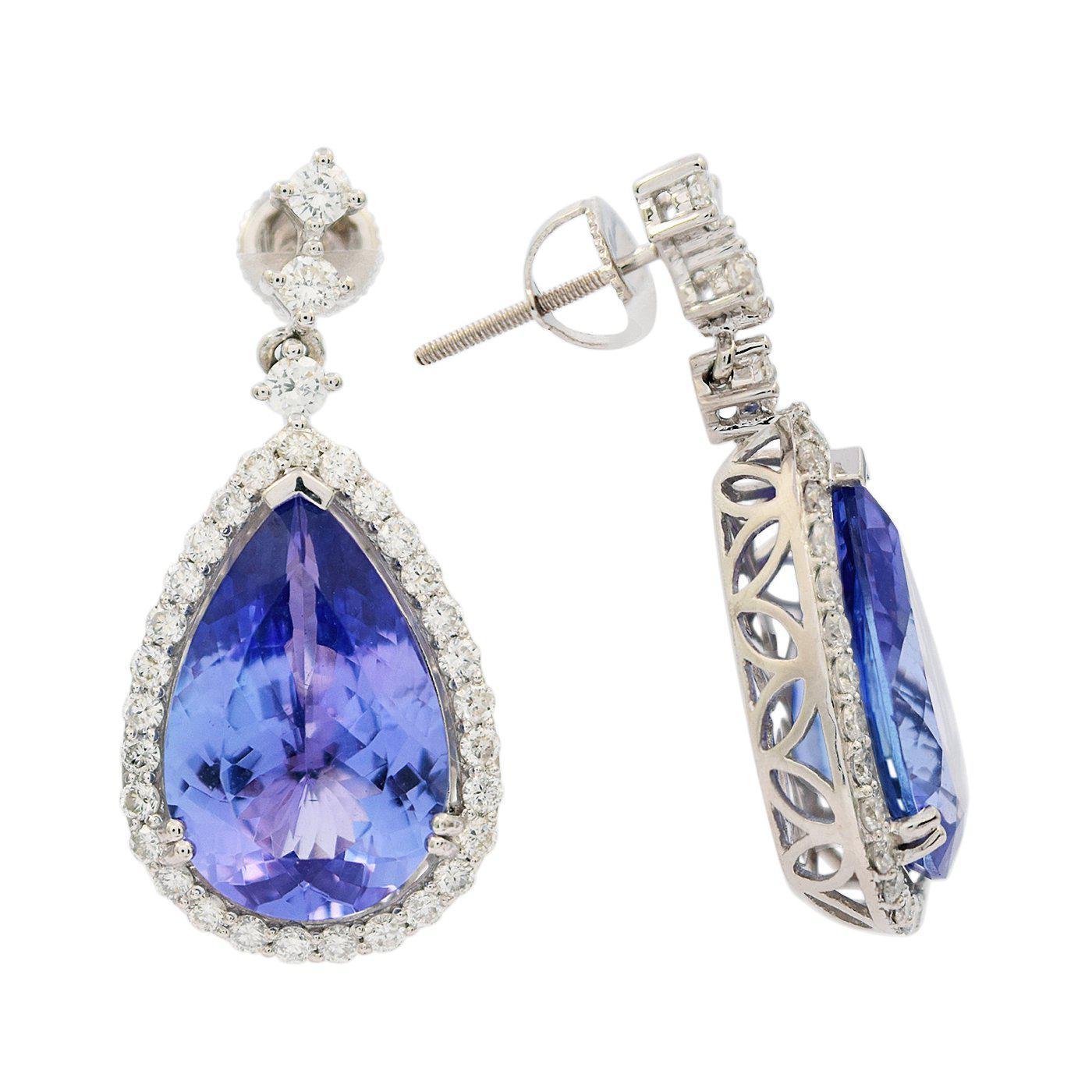 One pair electronically tested platinum ladies cast & assembled tanzanite and diamond dangle earrings with screw backs. Each earring features a tanzanite set within a diamond bezel suspended from a diamond ribbon. Bright polish finish. Identified