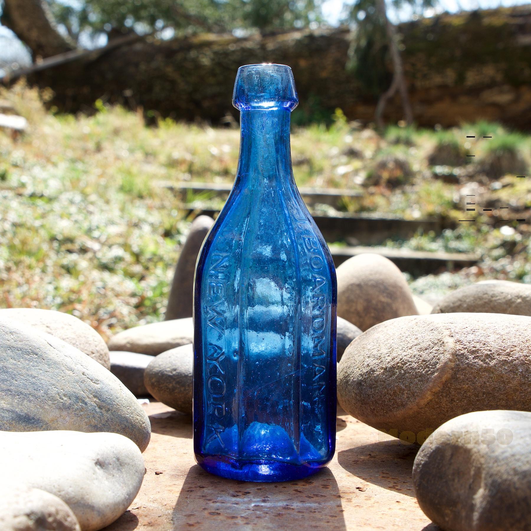 J. Boardman & Company New York Mineral Waters, this bottle is never sold. Soda water bottle, America, 1845-1860. Octagonal, bright, medium sapphire blue, applied sloping collared mouth - iron pontil mark, height 7 1/2 inches tall. Rare in very fine