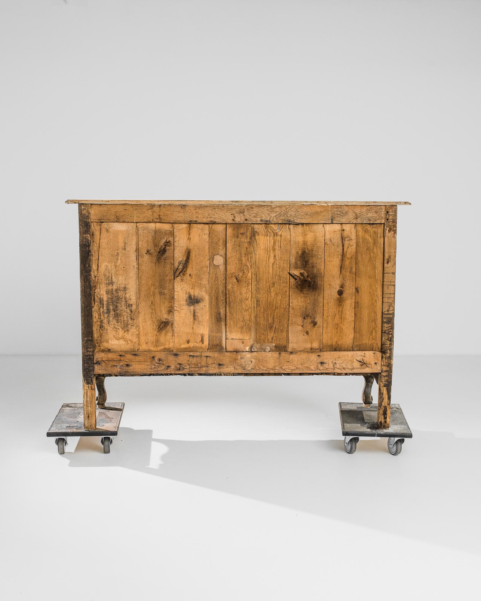 A bleached oak buffet from France, produced circa 1840. A chiselled buffet, featuring three sliding drawers and a lower double cabinet of two shelves, supported by a pair of cabriole front legs. A refined silhouette flanked by geometric panels,