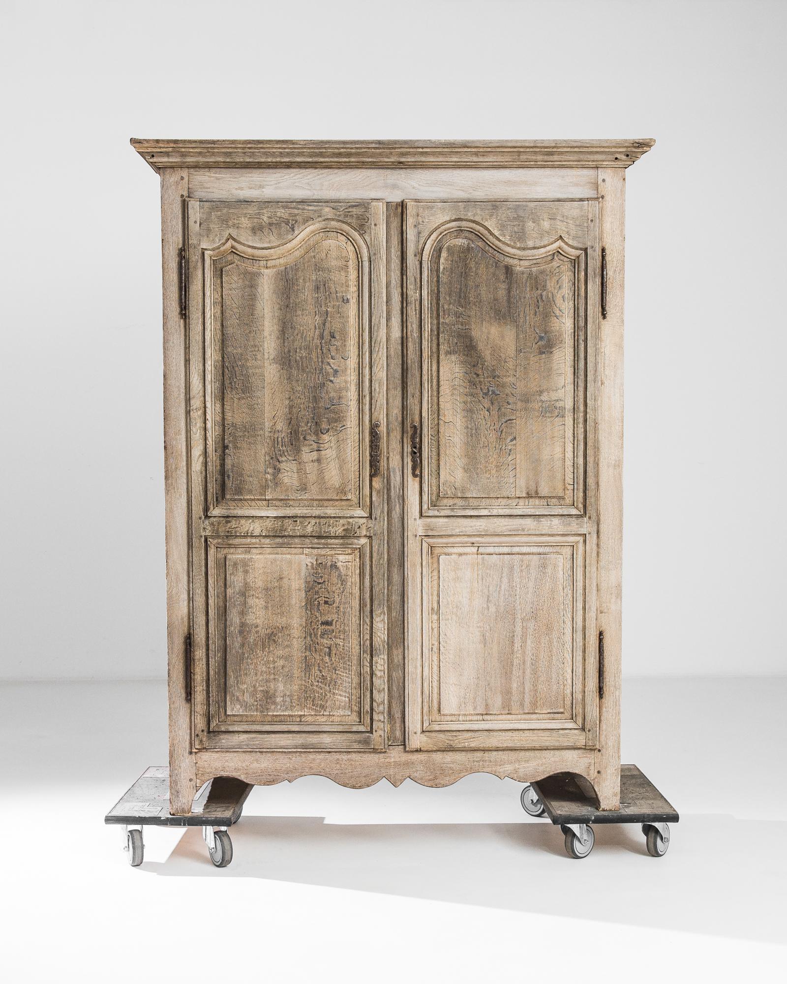 This 1840s French Bleached Oak Cabinet exudes the romantic allure of the French countryside with its rustic yet elegant design. The oak wood, treated delicately through a meticulous bleaching process, breathes new life into the grain, enhancing its