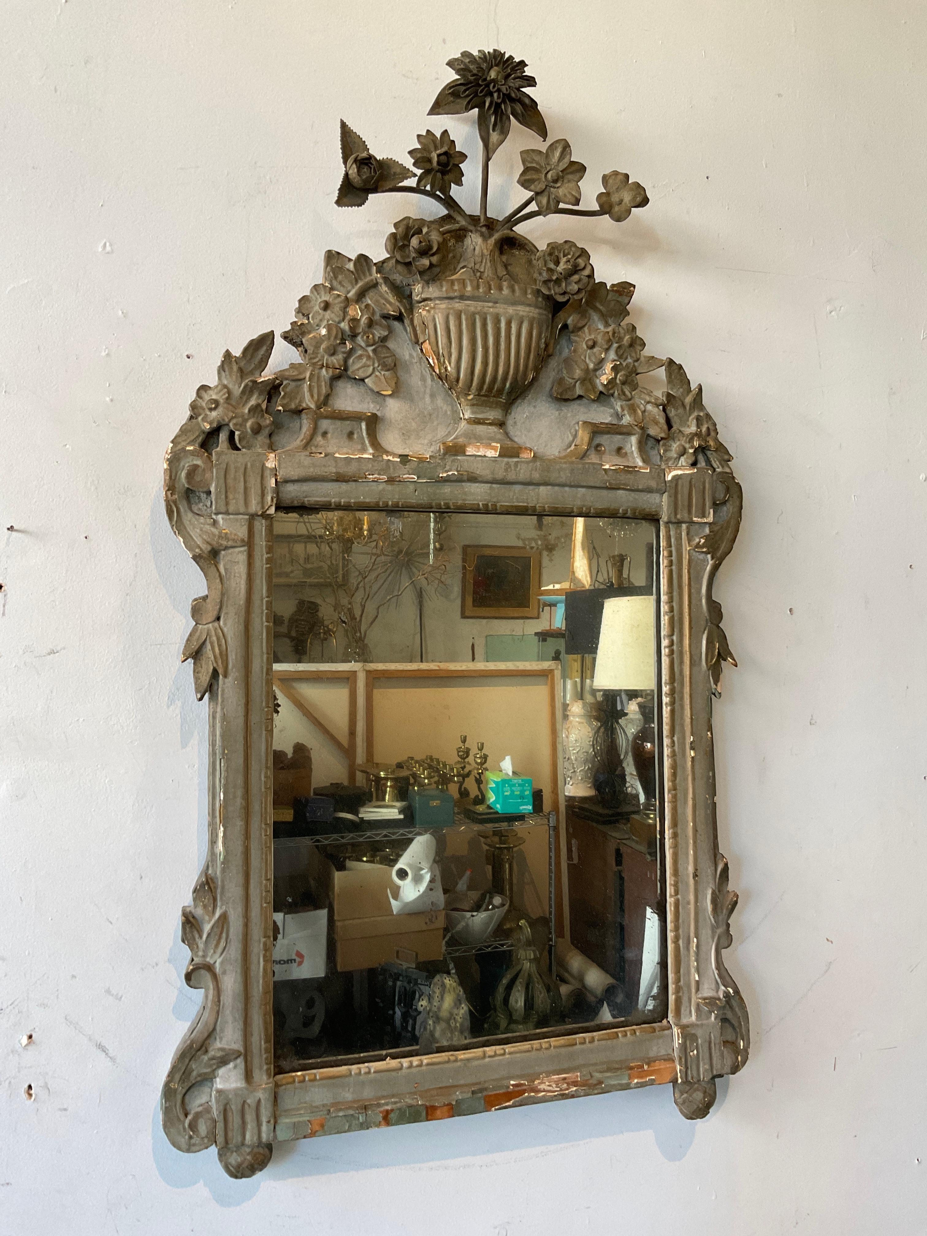 1840s Carved wood French mirror. Flowers on top are metal.  Mirror has dark spots on it from age. Pint loss to frame.