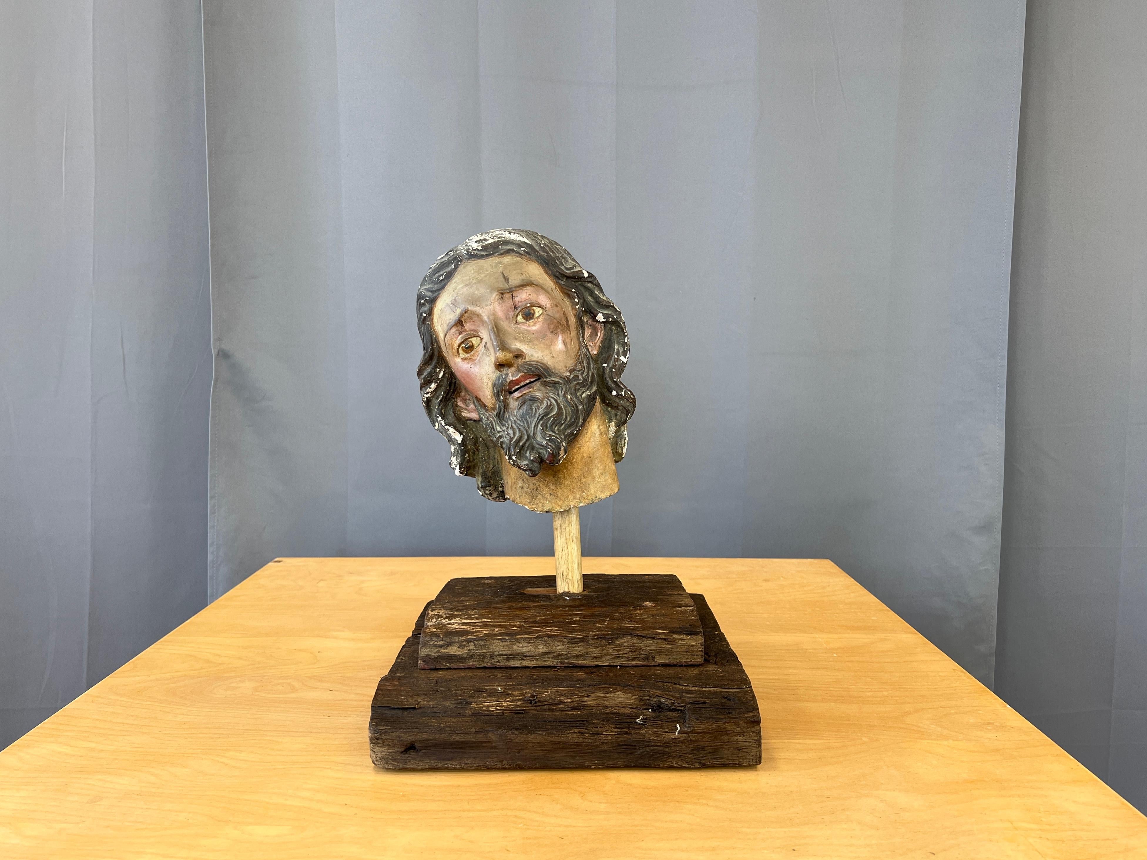 Plaster and Gesso head of a Saint Italian. 
Rustic wooden base, with a wood post which in turns holds the post coming out from under the head.
Head is made of plaster and gesso, black wavy beard and hair, very dark colored skin, with a stare off