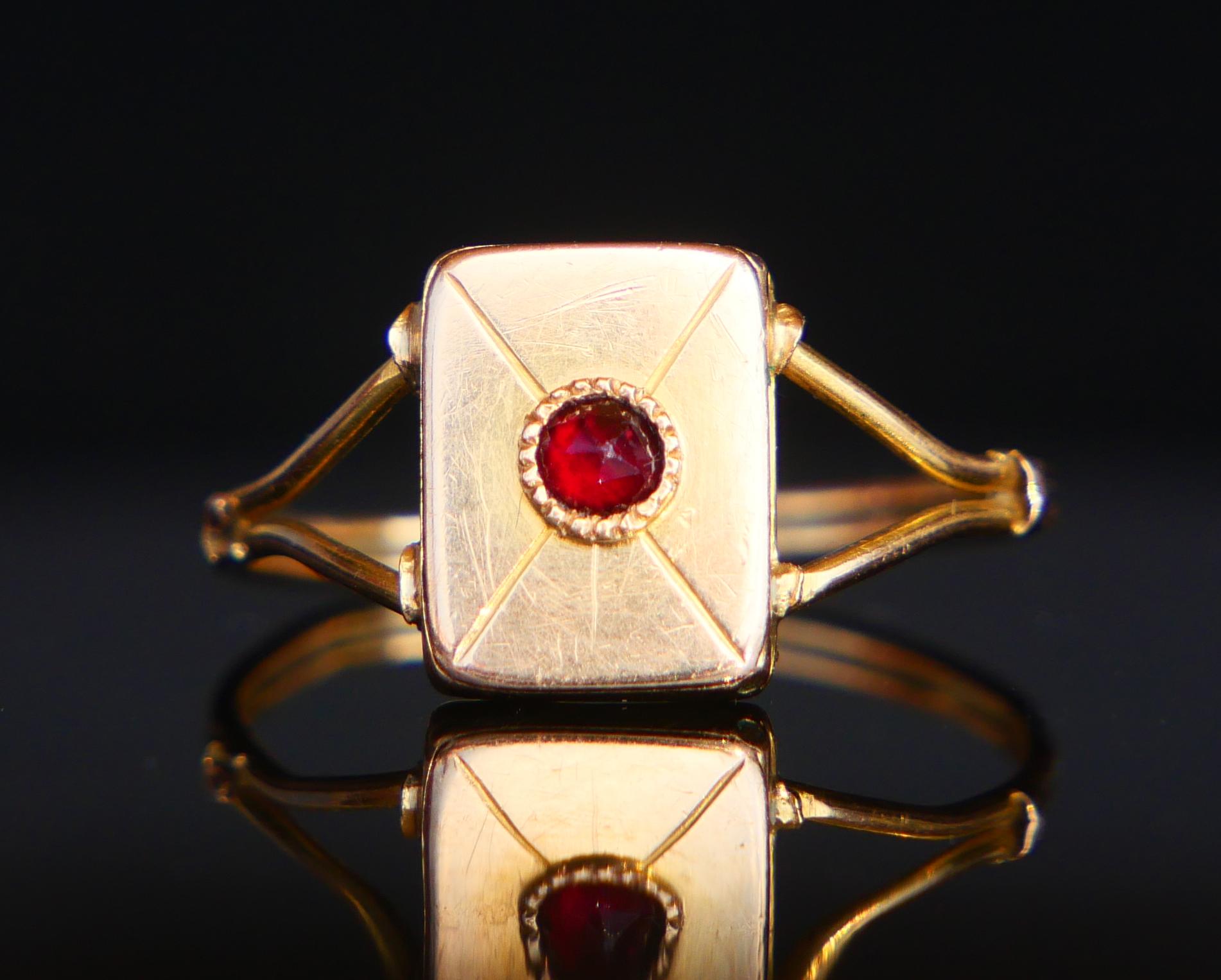 Poison Ring in solid 18K Yellow Gold with a hinged compartment on the crown. Hand- engraved Envelope pattern on top of the crown decorated with a bezel set rose cut Garnet stone Ø 2.5 mm .

It shuts pretty tightly and can only be lifted using a tip