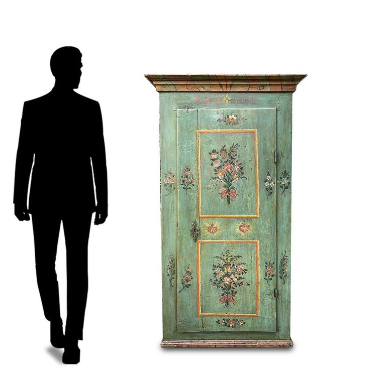 Painted wardrobe dated 1848

Measures: H.161 - L.78 (90 to the frames) - P.38 (43 to the frames)

Tyrolean wardrobe / cupboard with one door, painted in petrol green. On the door two framed panels depict cups and bouquets of flowers. On the