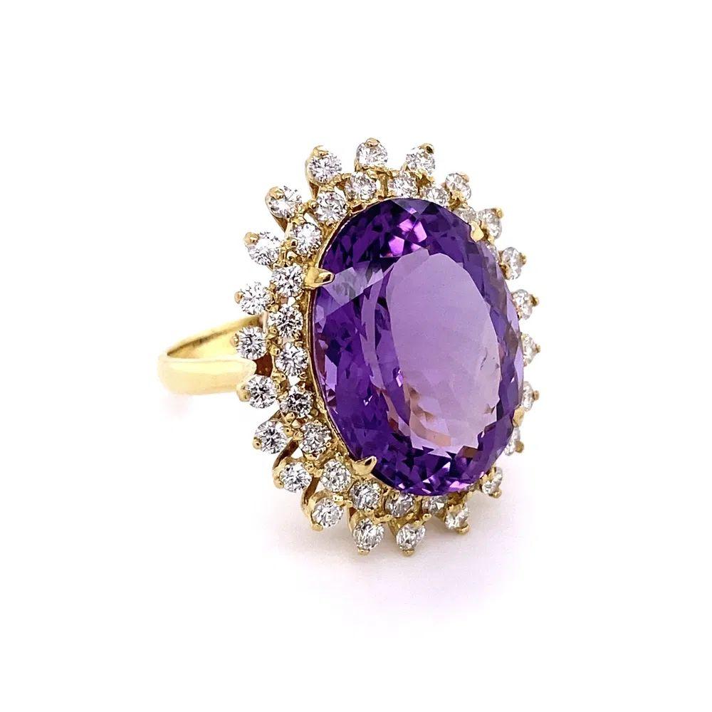 Simply Beautiful! Vintage Solitaire Amethyst and Diamond Gold Ring. Centering a securely nestled and Hand set 18.48 Carat Oval Amethyst. Surrounded by Diamonds, weighing approx. 2.11tcw. Hand crafted Yellow Gold mounting. Wow! Ring size 11, we offer