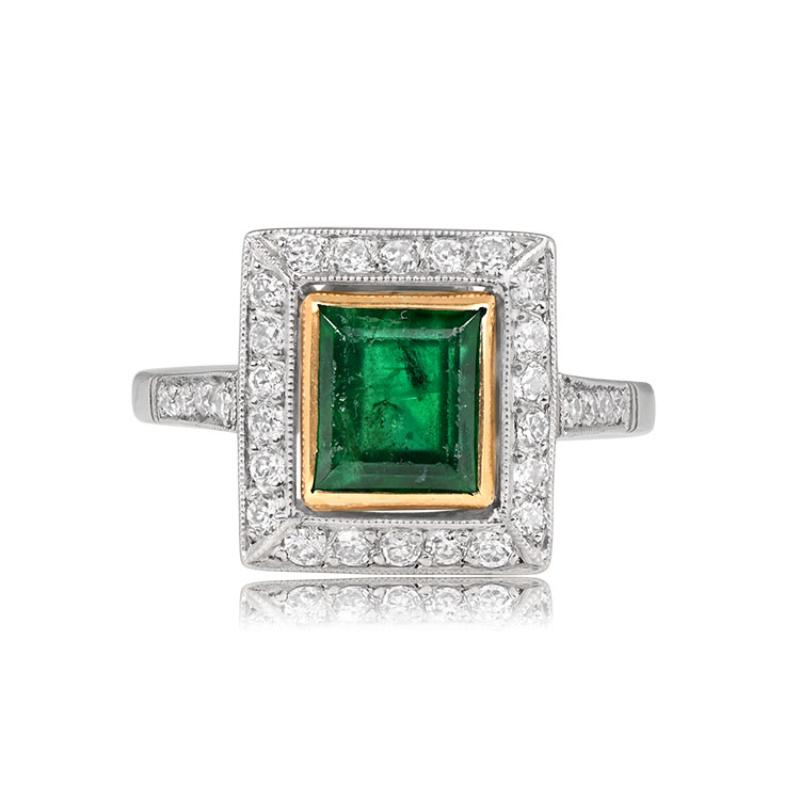 A captivating ring showcasing a 1.84-carat emerald in an emerald cut, bezel set in 18k yellow gold. The emerald is surrounded by a halo of pave-set old European cut diamonds, while more diamonds grace the shoulders. The ring is a blend of yellow