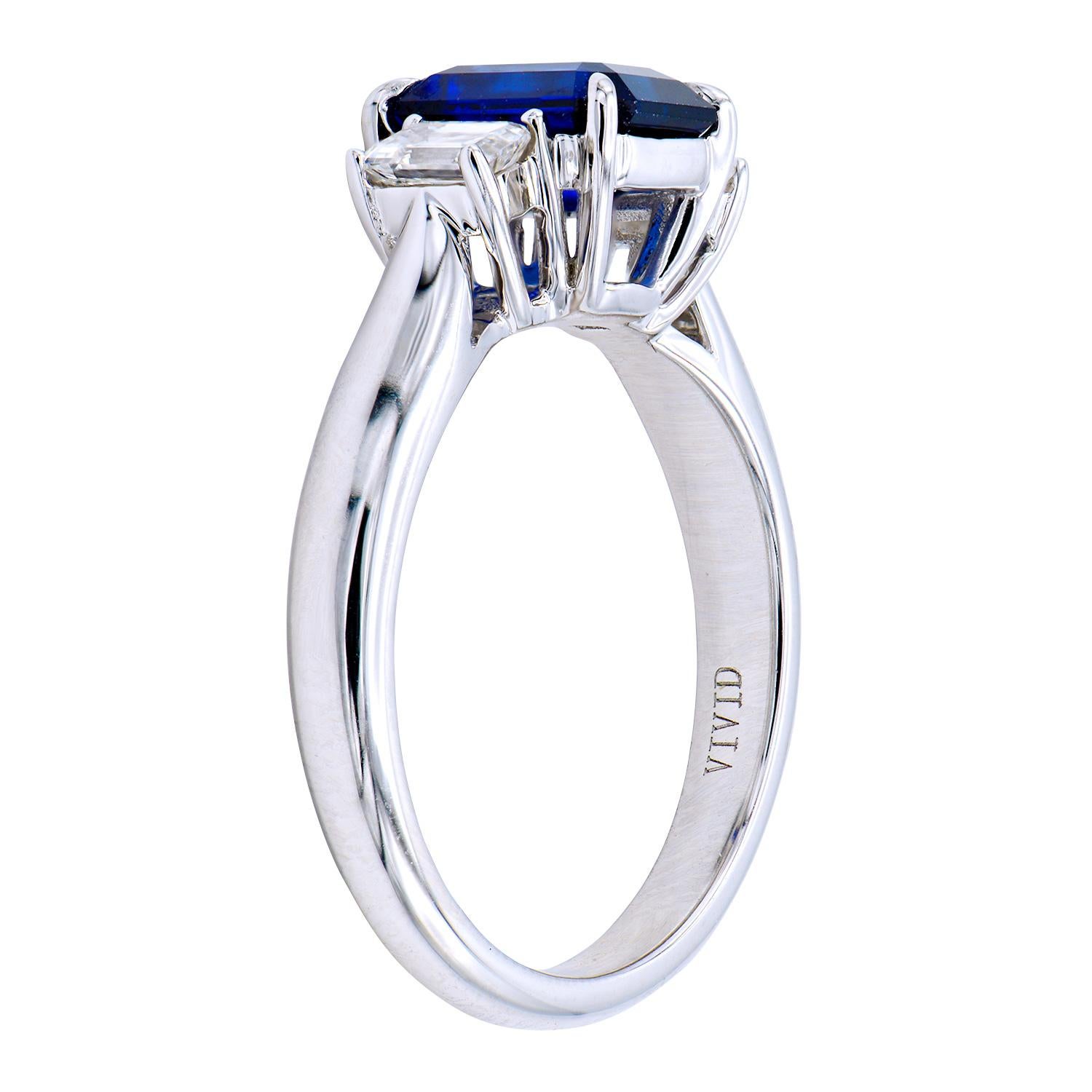 This gorgeous 1.85 carat Ceylon, Emerald Cut, Blue Sapphire is set in 4.6 grams of 18 karat white gold. On either side of the sapphire are 2 Emerald-cut Diamonds totaling 0.43 carats. All together they make a stunning three-stone ring that is a size