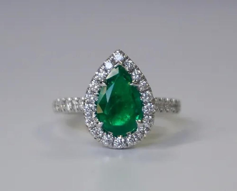 Emerald Weight: 1.85 ct, Measurements: 11x7 mm, Diamond Weight: 0.62 ct, Metal: 18K White Gold, Metal Weight: 6.04 gm, Ring Size: 6.5, Shape: Pear, Color: Vivid Green, Hardness: 7.5-8, Birthstone: May, Origin: Zambia