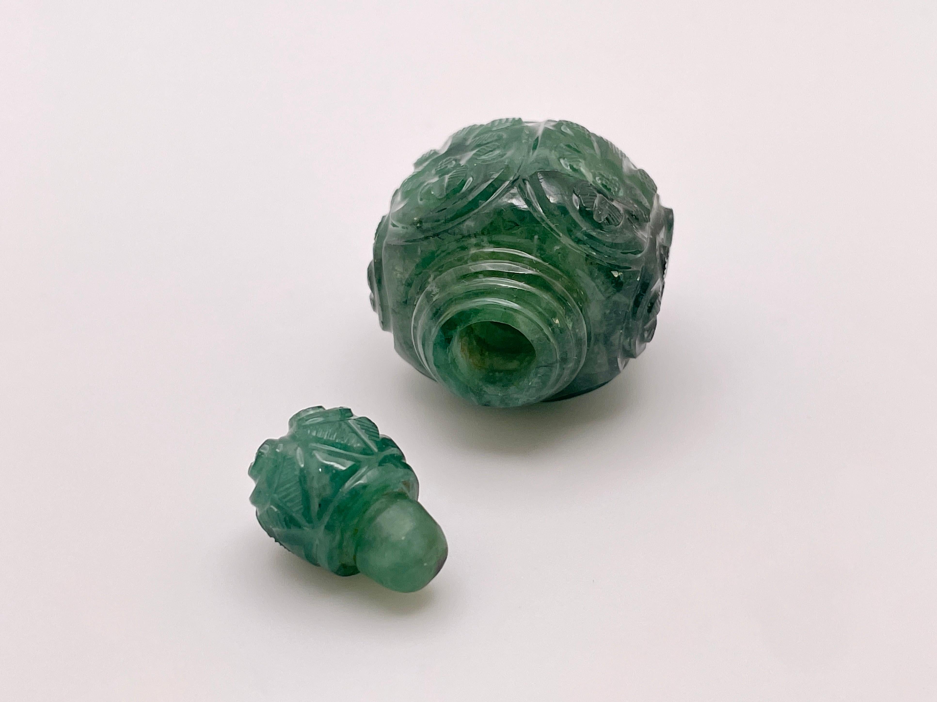 This estate 185 Carat (CT) carved natural emerald perfume bottle with matching carved emerald stopper is a stunning antique piece, presented with its original box. The bottle features intricate hand-carved detailing from top to bottom, showcasing