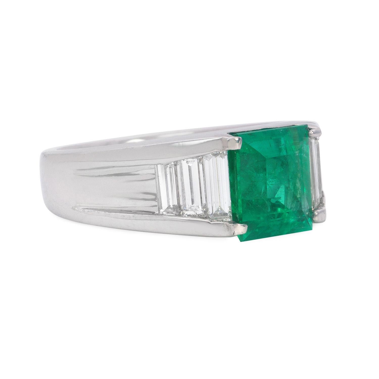 The 1.85 Carat green natural Colombian emerald with baguette diamonds is a stunning piece of jewelry. The centerpiece of the ring is a vivid green emerald, originating from Colombia, known for producing some of the world's finest emeralds. The